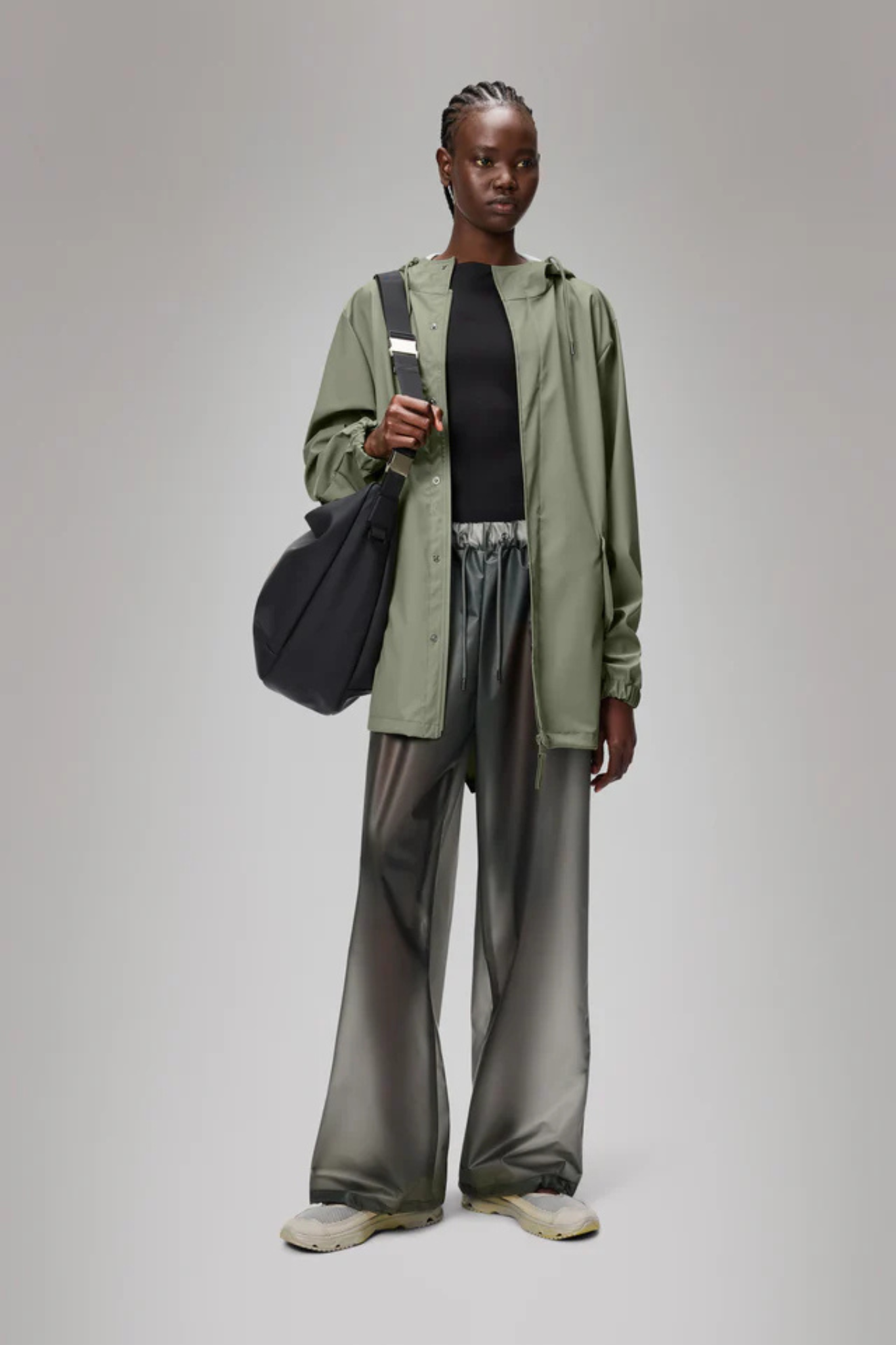 Model wearing the Rains fishtail jacket W3 in green. Front view