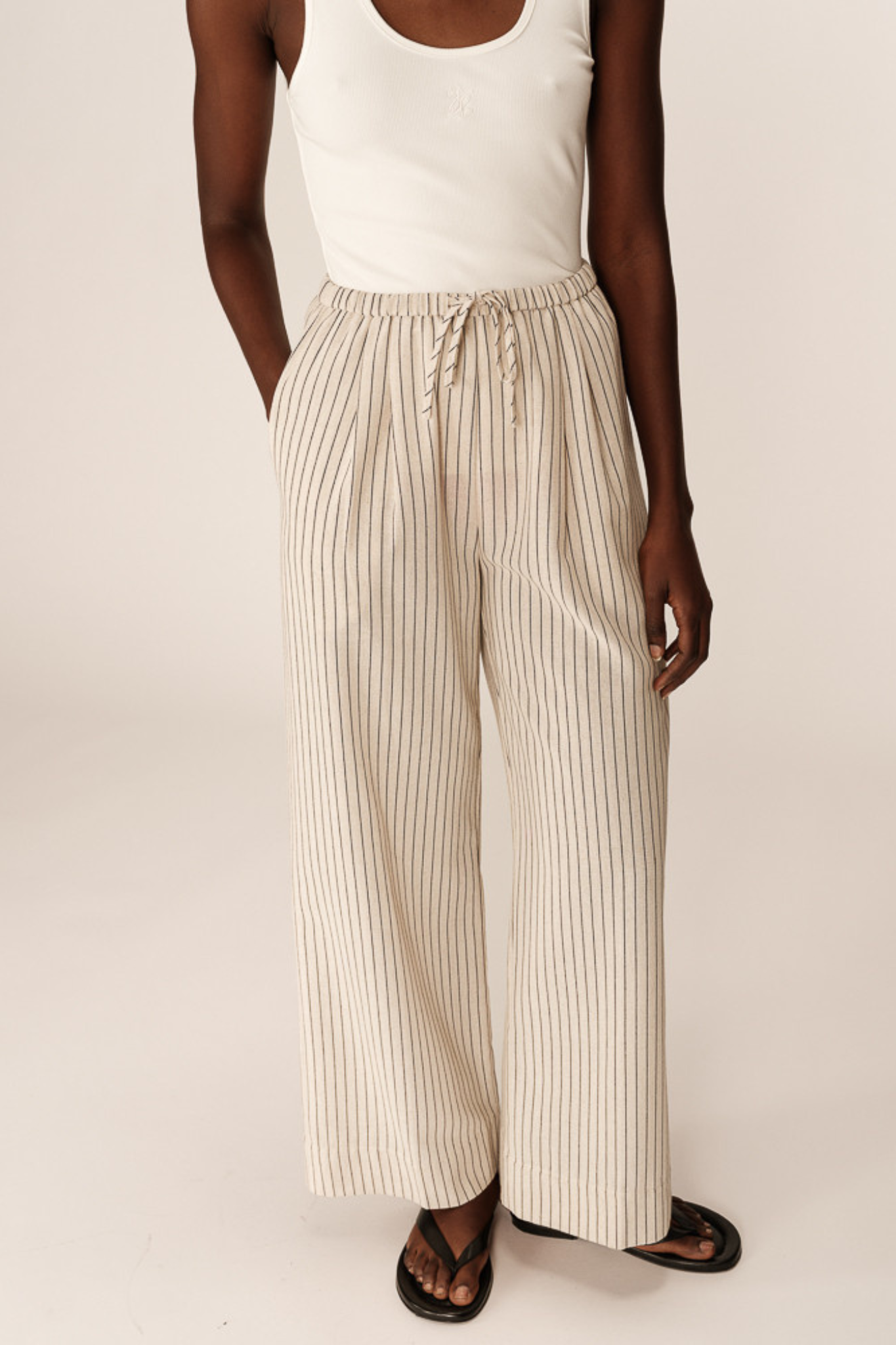 Model wearing the Grace & Mila perry pants in beige and black striped. Front view
