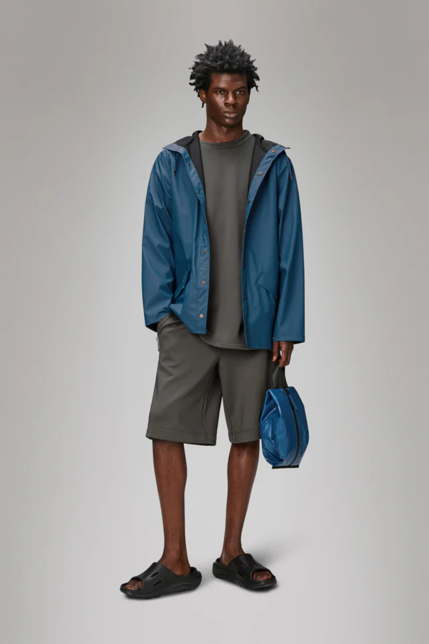 Model wearing the Rains jacket W3 in blue. Front view