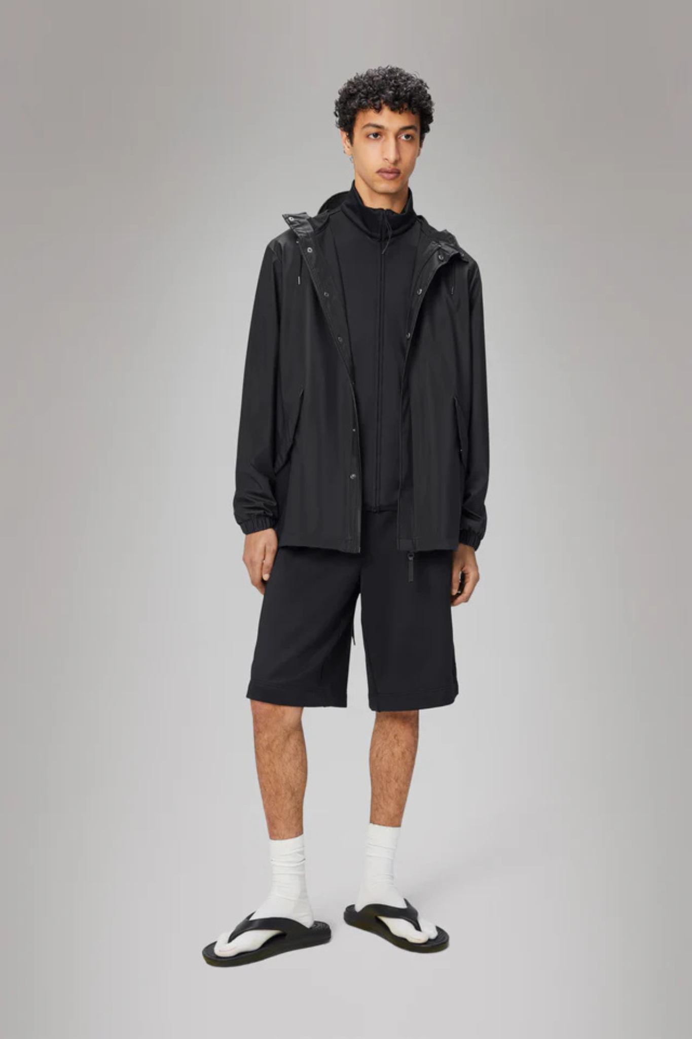 Model wearing the Rains fishtail jacket W3 in black. Front view