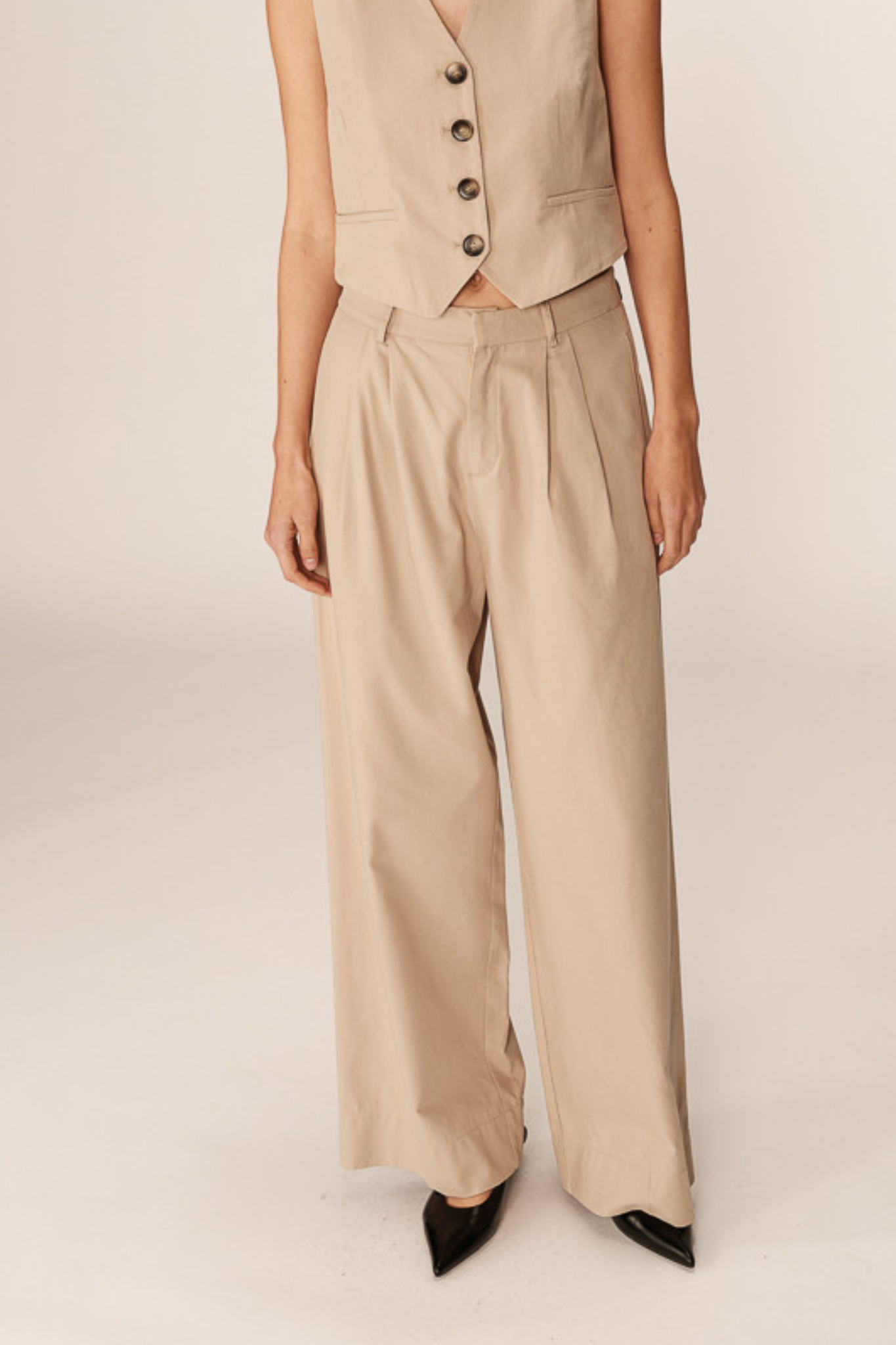 Model wearing the Grace & Mila peter pants in beige. Front view