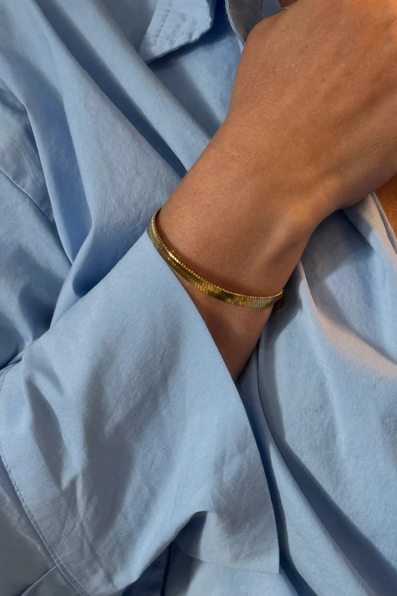 Model wearing the Maste lilou bracelet in gold.