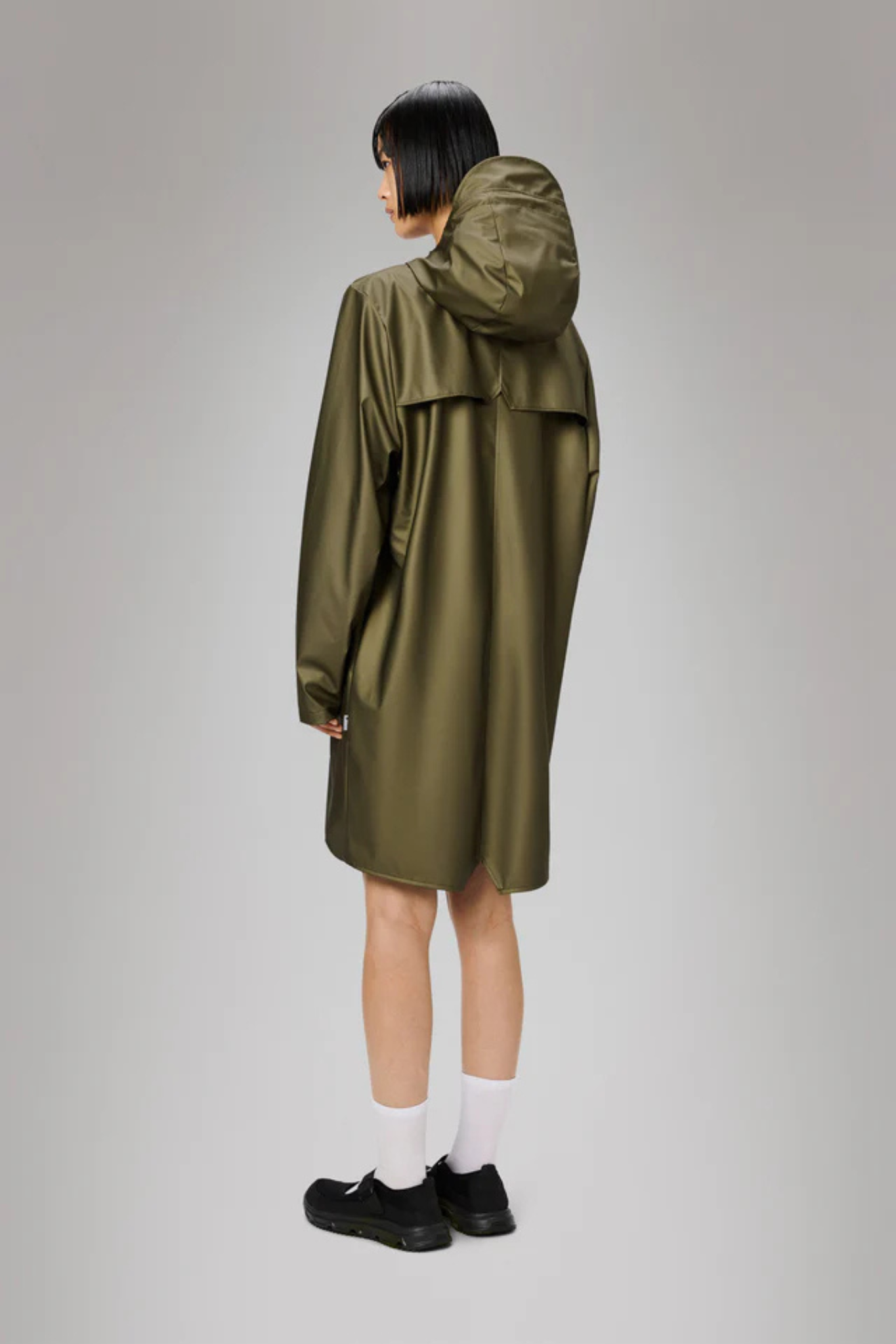 Model wearing the Rains long jacket W3 in khaki. Back view