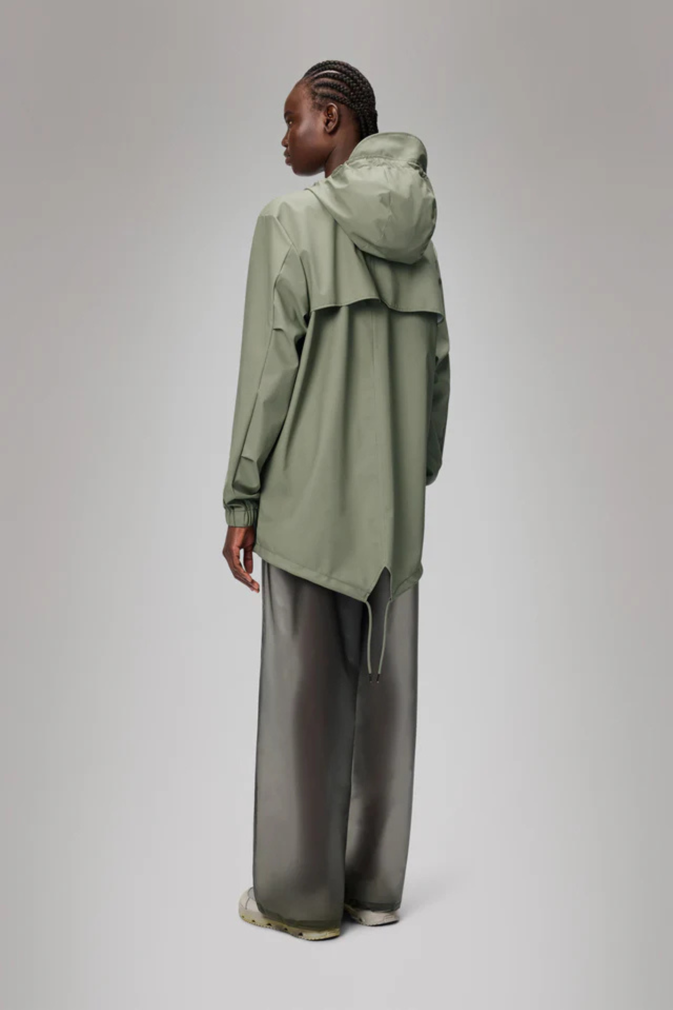 Model wearing the Rains fishtail jacket W3 in green. Back view
