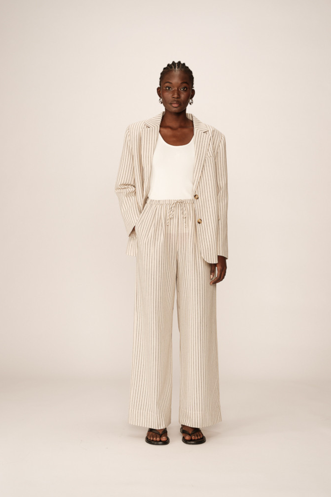 Model wearing the Grace & Mila perry pants in beige and black striped. Front view