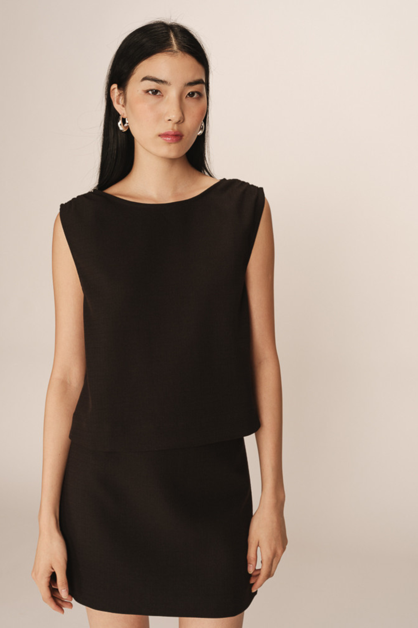 Model wearing the Grace & Mila pekin mini skirt in black. Front view