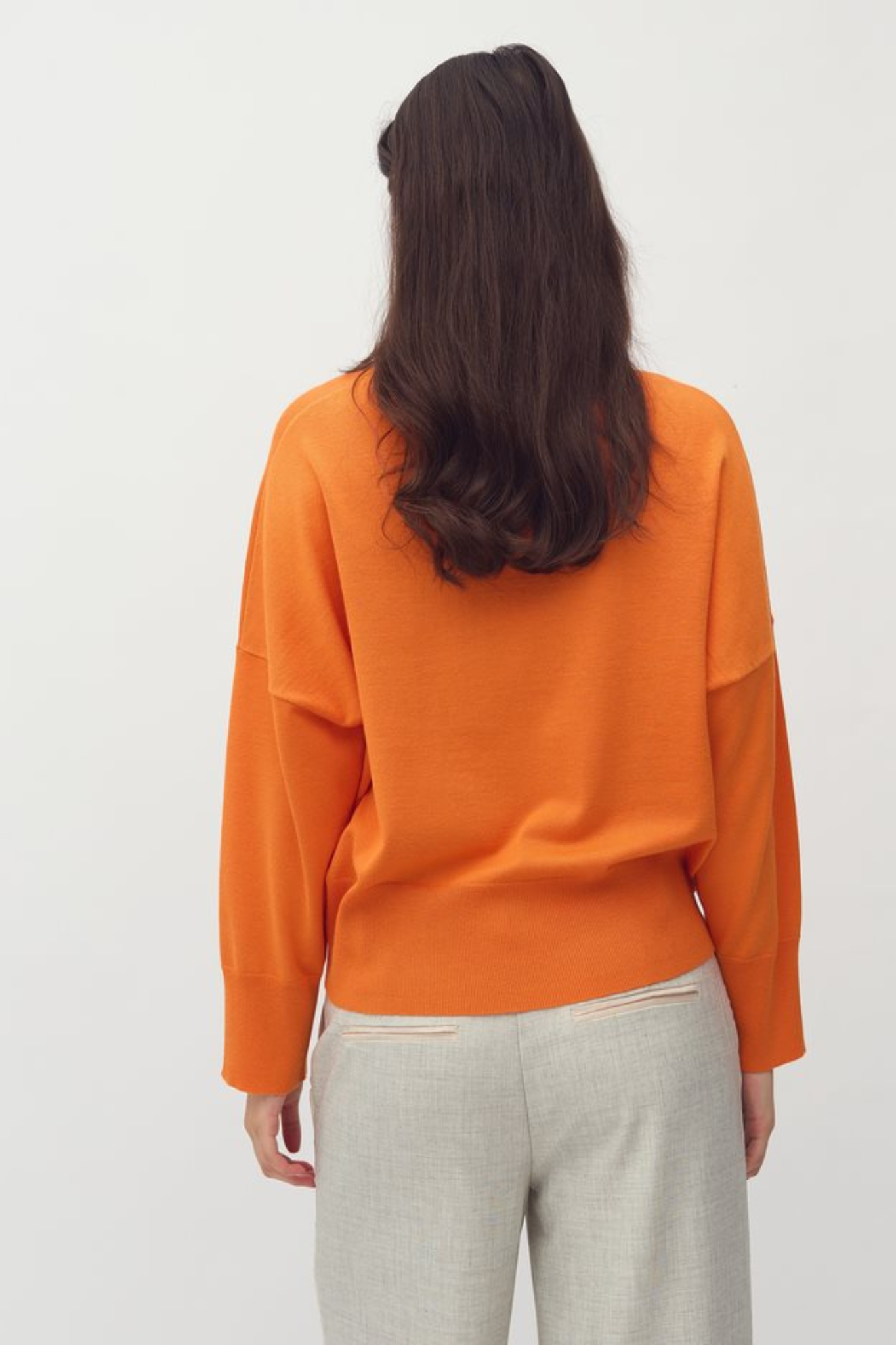 Model wearing the MBYM bravani gillian knit in orange peel. Back view