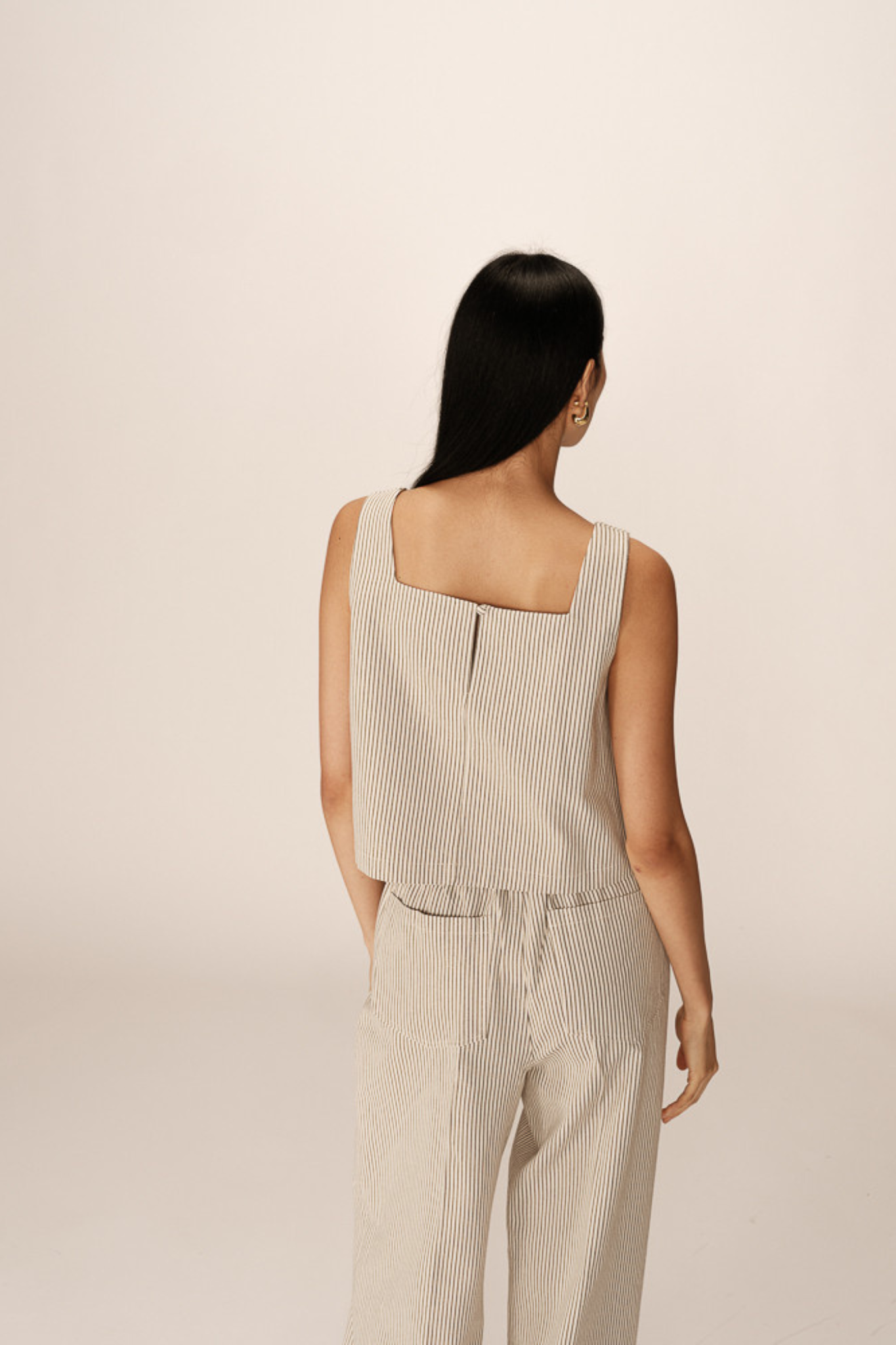 Model wearing the Grace & Mila peanut top in ecru. Back view