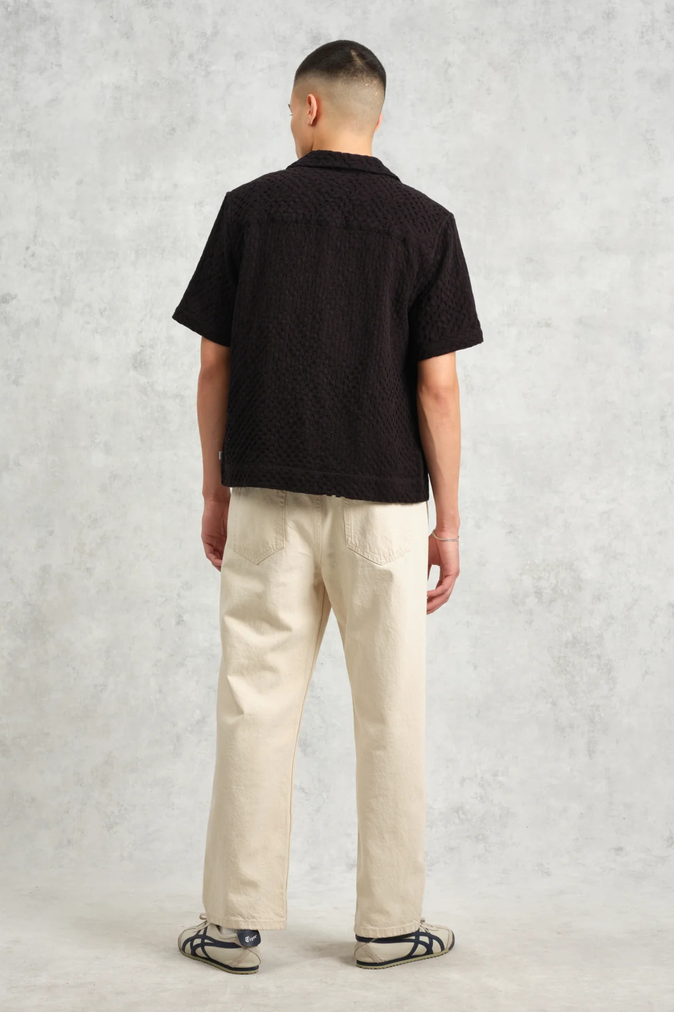 Model wearing the Wax London lido box dobby shirt in black. Back view