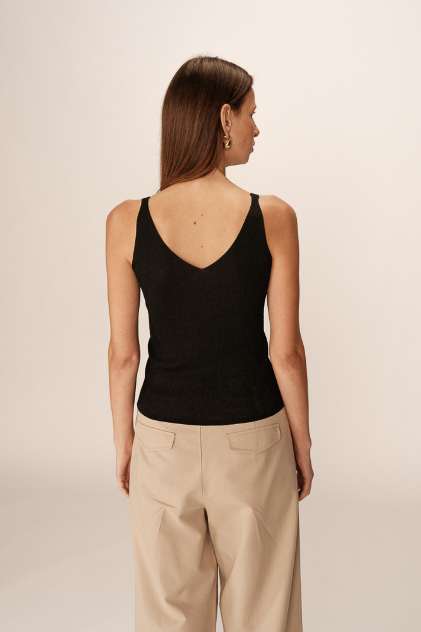 Model wearing the Grace & Mila paillette top in black. Back view