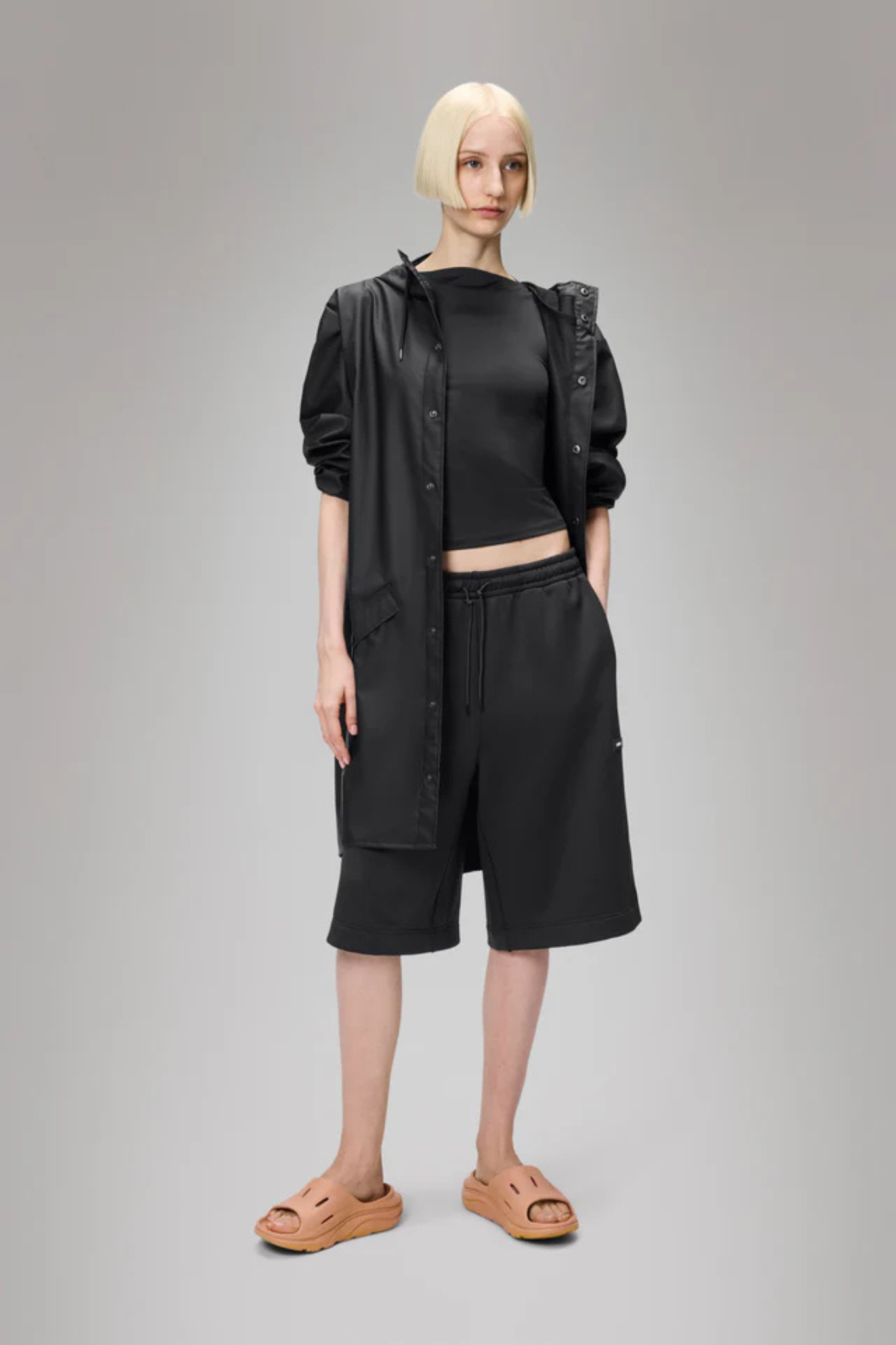Model wearing the Rains long jacket W3 in black. Front view