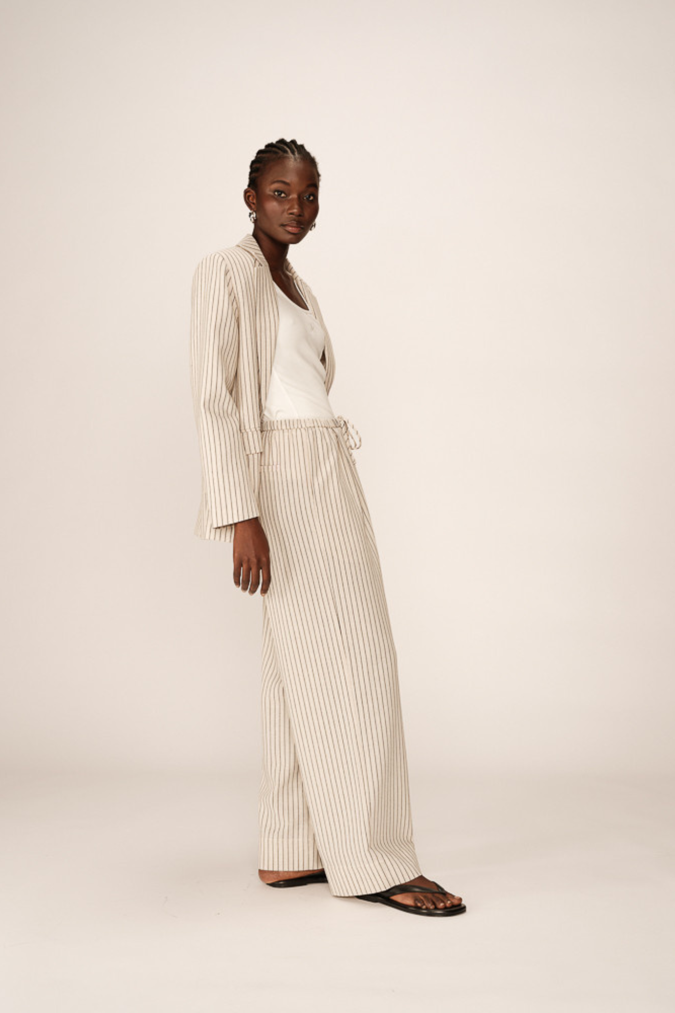 Model wearing the Grace & Mila perry pants in beige and black striped. Side view