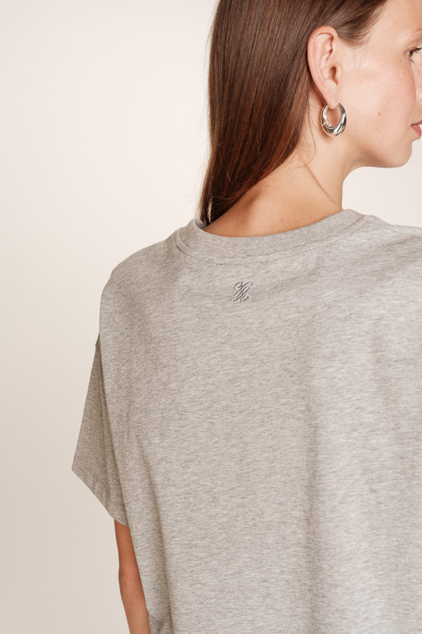 Model wearing the Grace & Mila rodin t-shirt in grey. Back view
