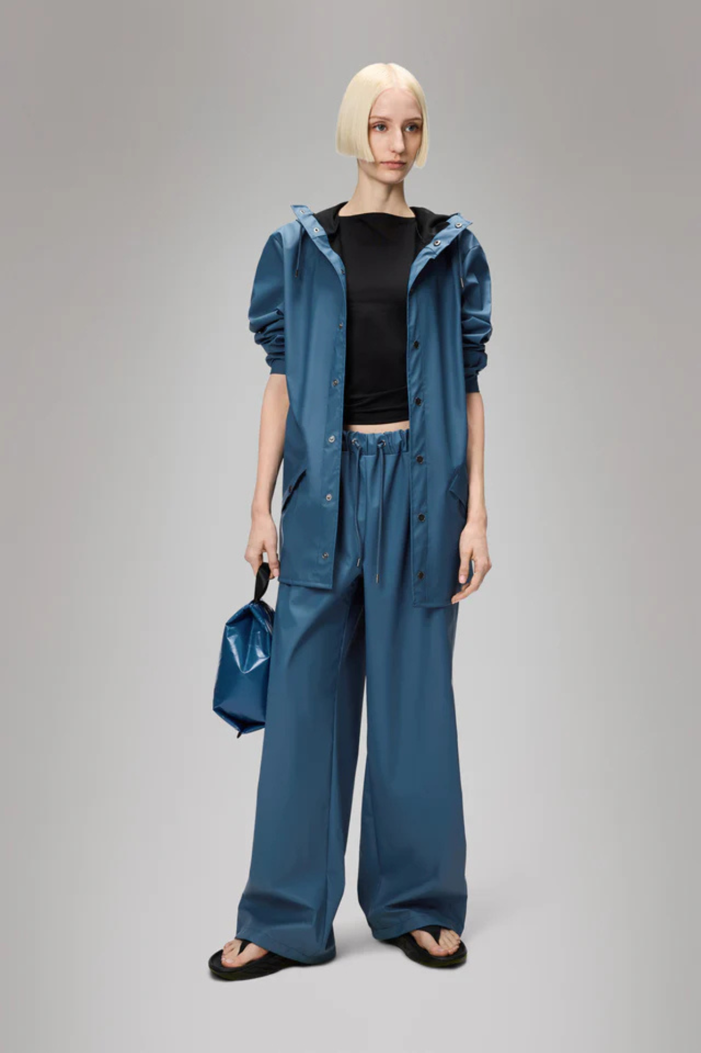 Model wearing the Rains jacket W3 in blue. Front view