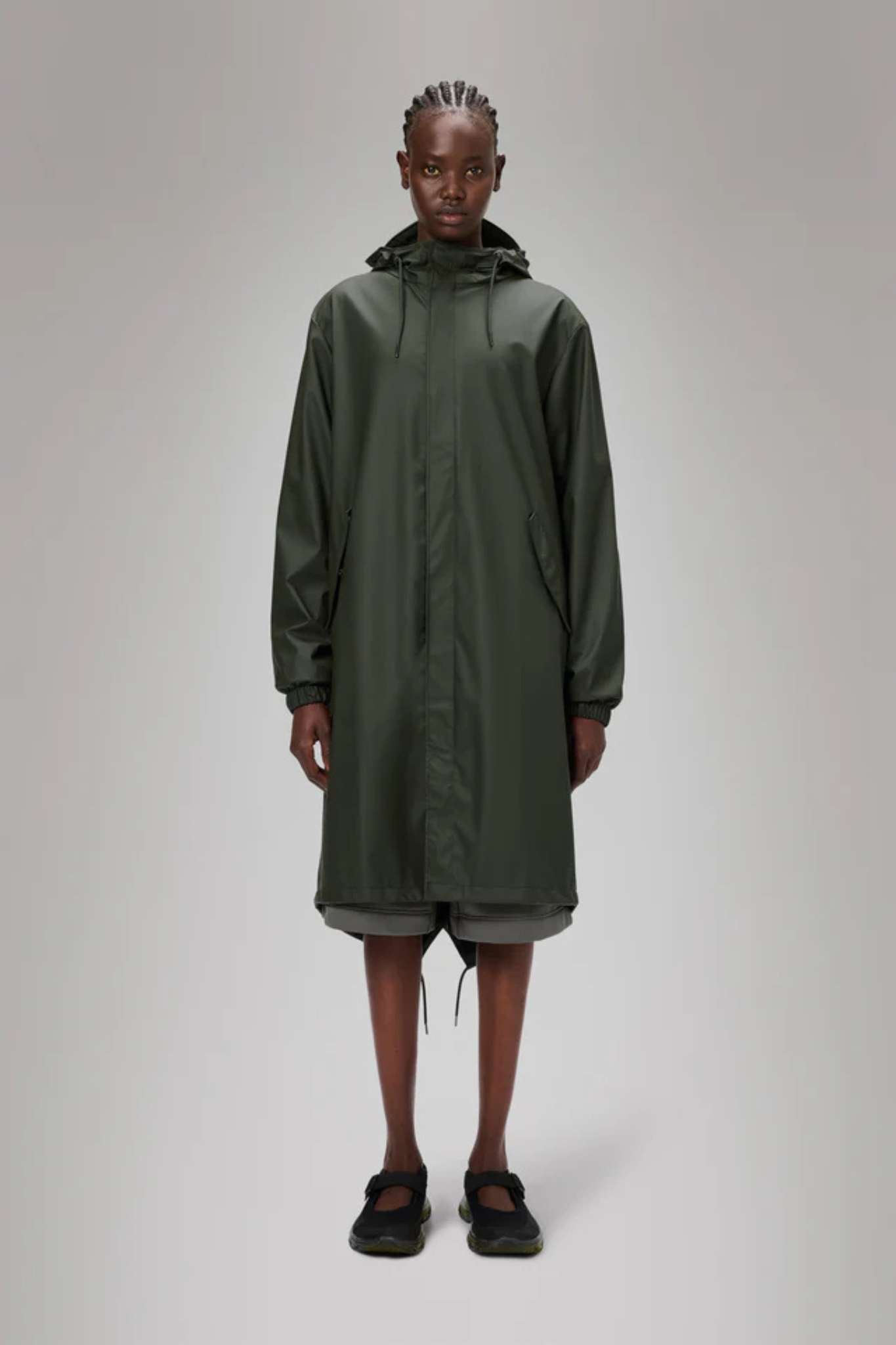 Model wearing the Rains fishtail parka W3 in green. Front view