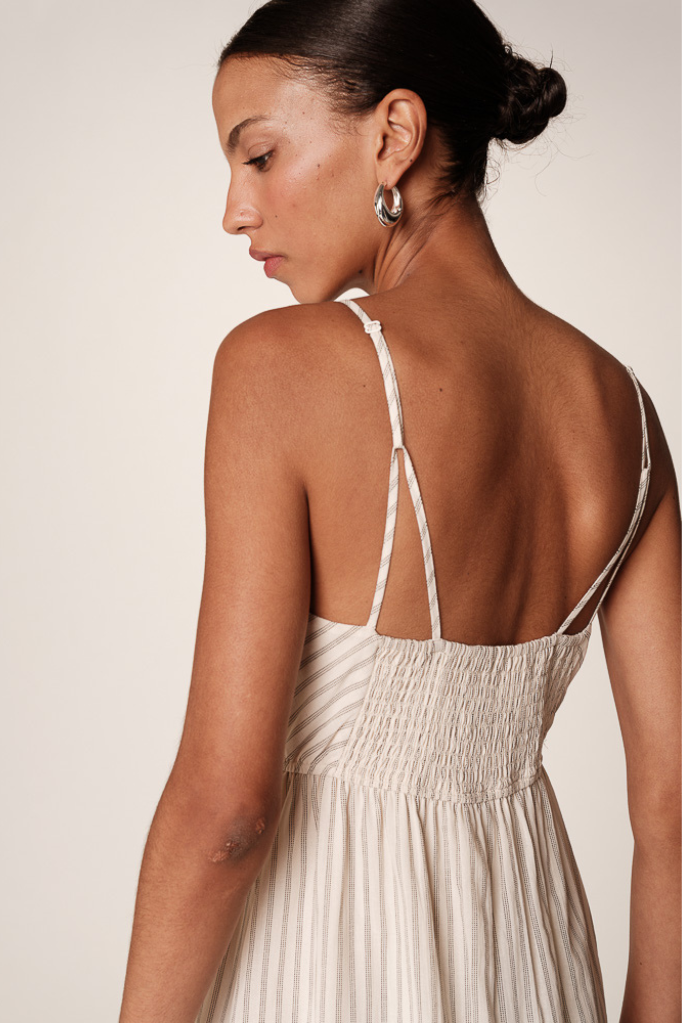 Model wearing the Grace & Mila raja dress in ecru. Close back view