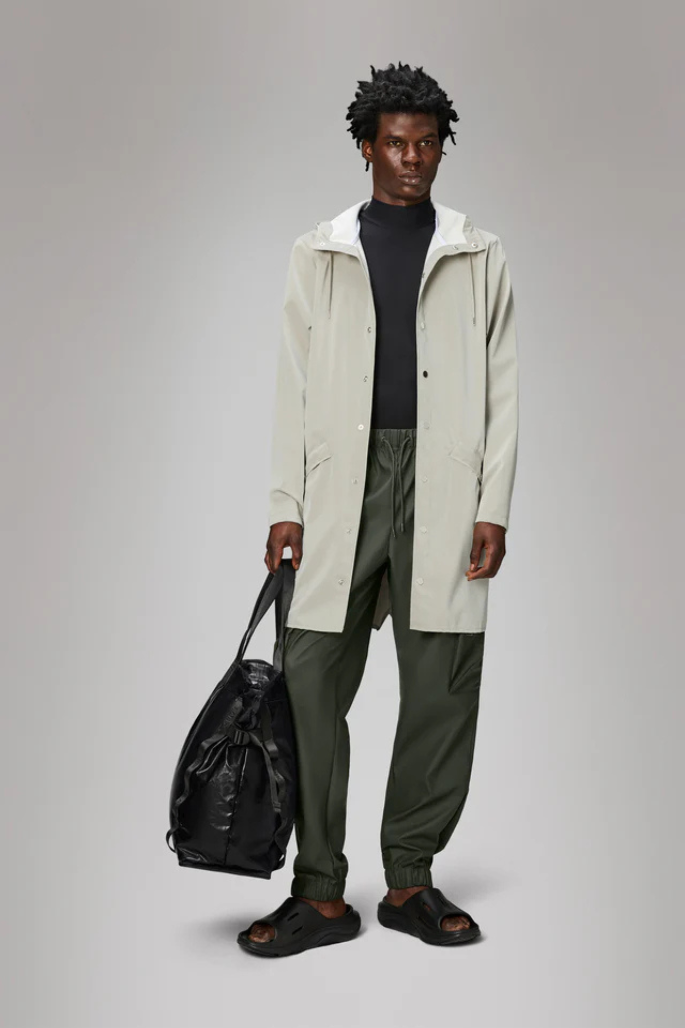 Model wearing the Rains long jacket W3 in white. Front view