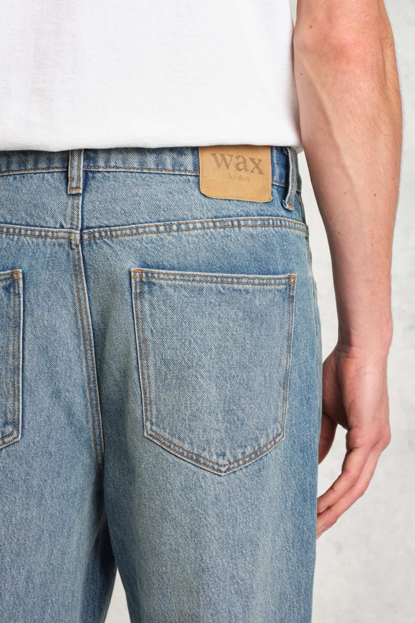 Model wearing the Wax London russel straight fit vintage denim jeans in vintage blue. Close back view
