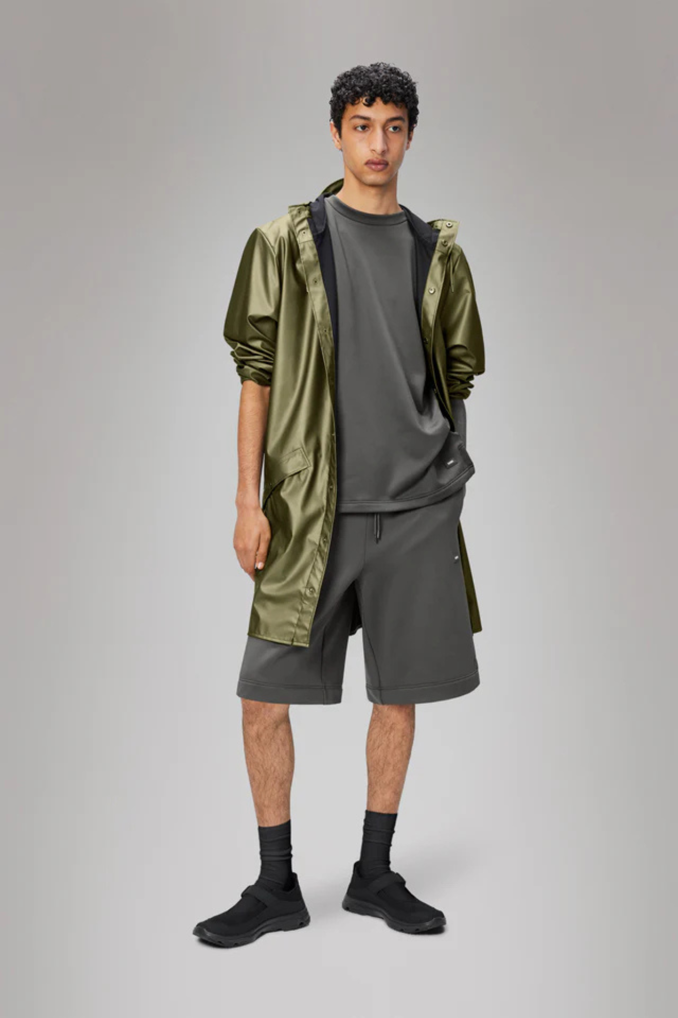 Model wearing the Rains long jacket W3 in khaki. Front view