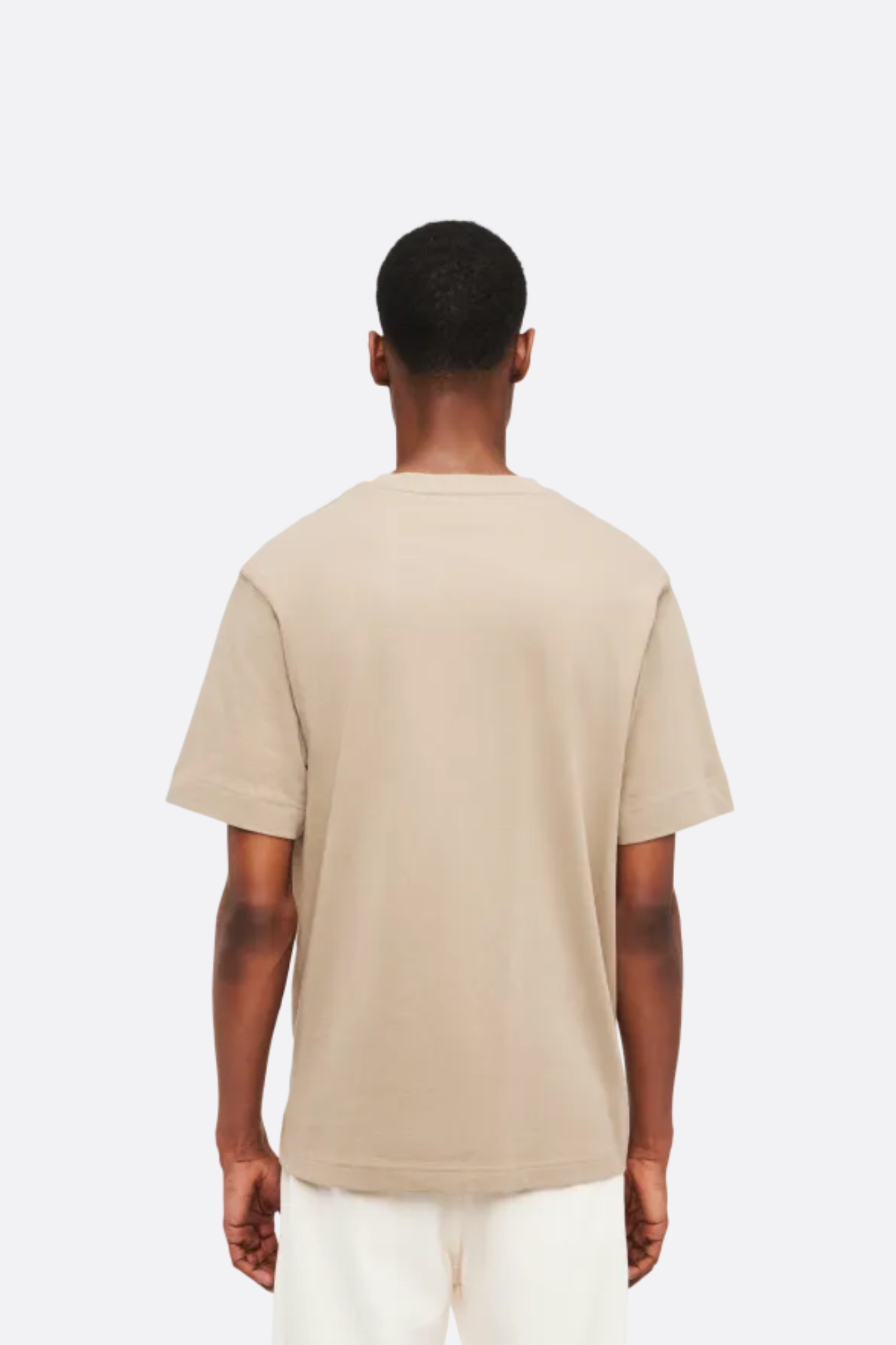 Model wearing the Drykorn raphael t-shirt in beige. Back view