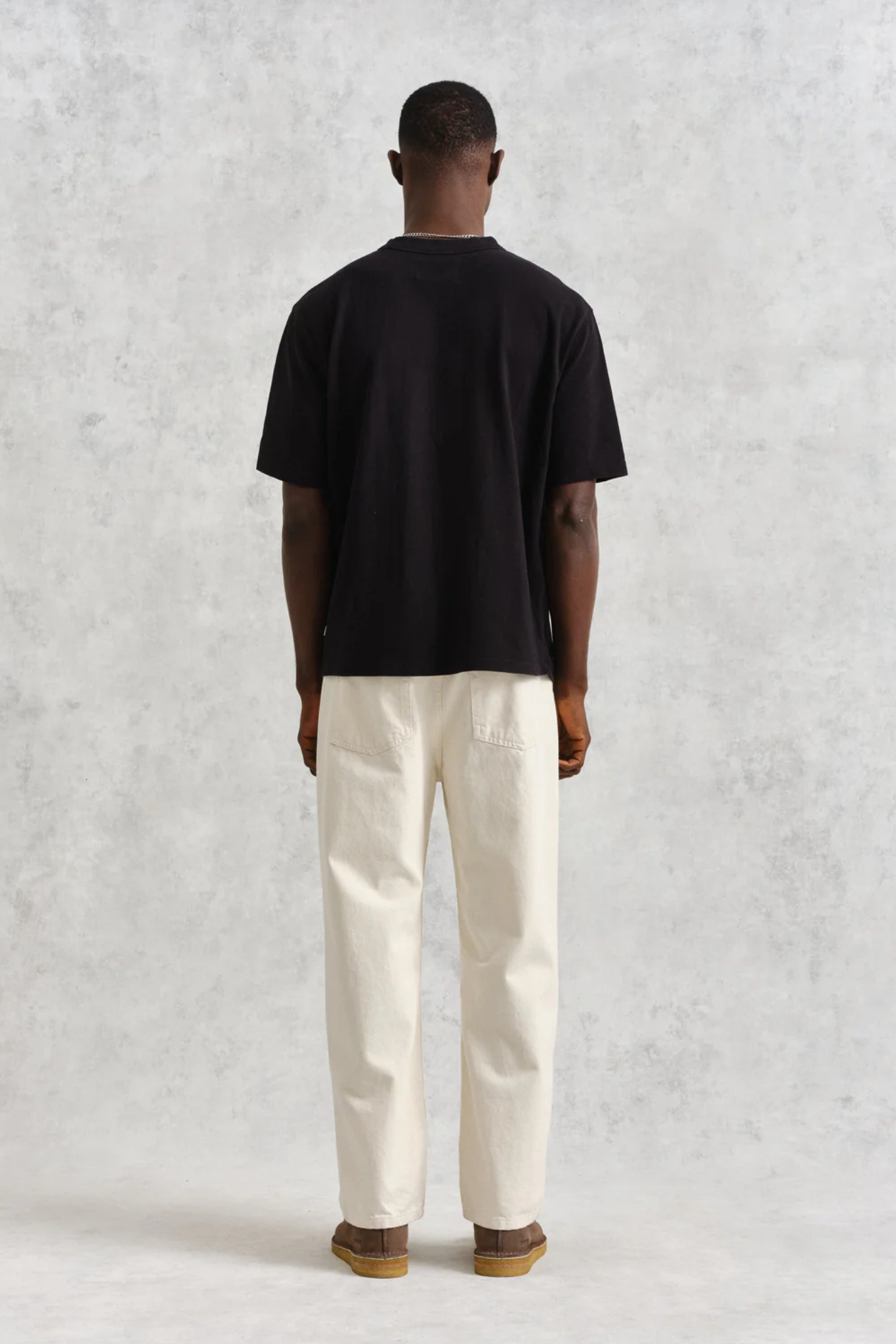 Model wearing the Wax London milton t-shirt in black. Back view