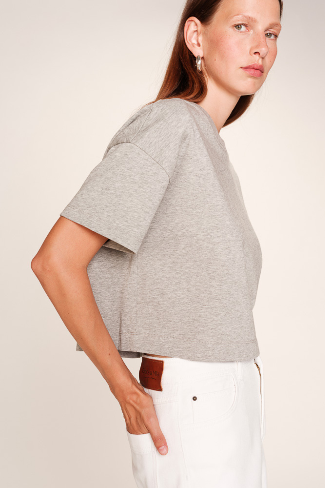 Model wearing the Grace & Mila rodin t-shirt in grey. Side view