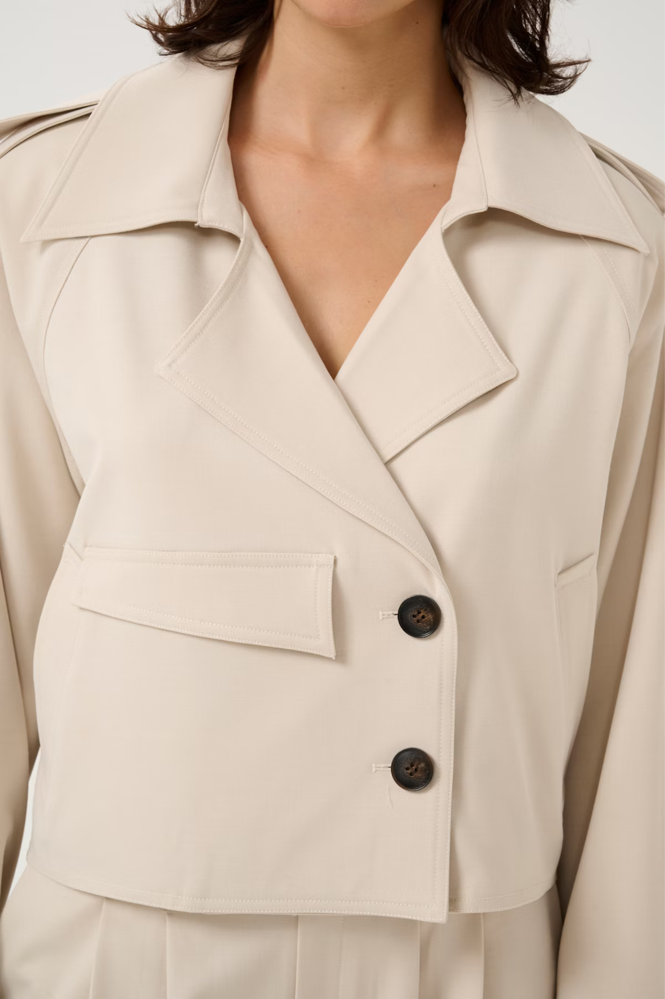 Model wearing the Gestuz zedina short jacket in beige. Front view