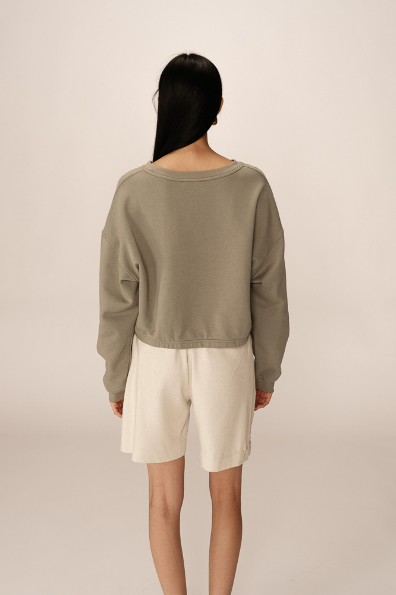 Model wearing the Grace & Mila podium sweatshirt in green. Back view