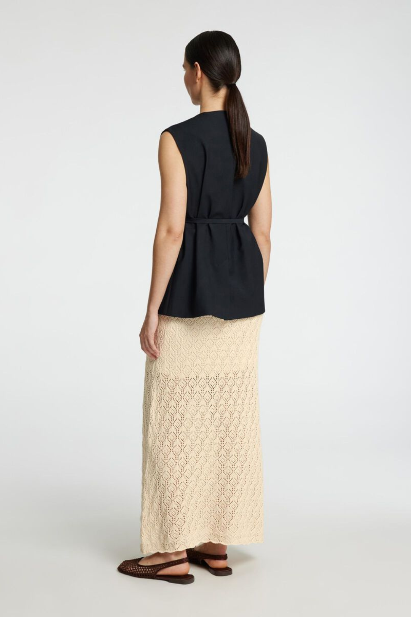 Model wearing the Selected Femme niva hw knit skirt in birch. Back view