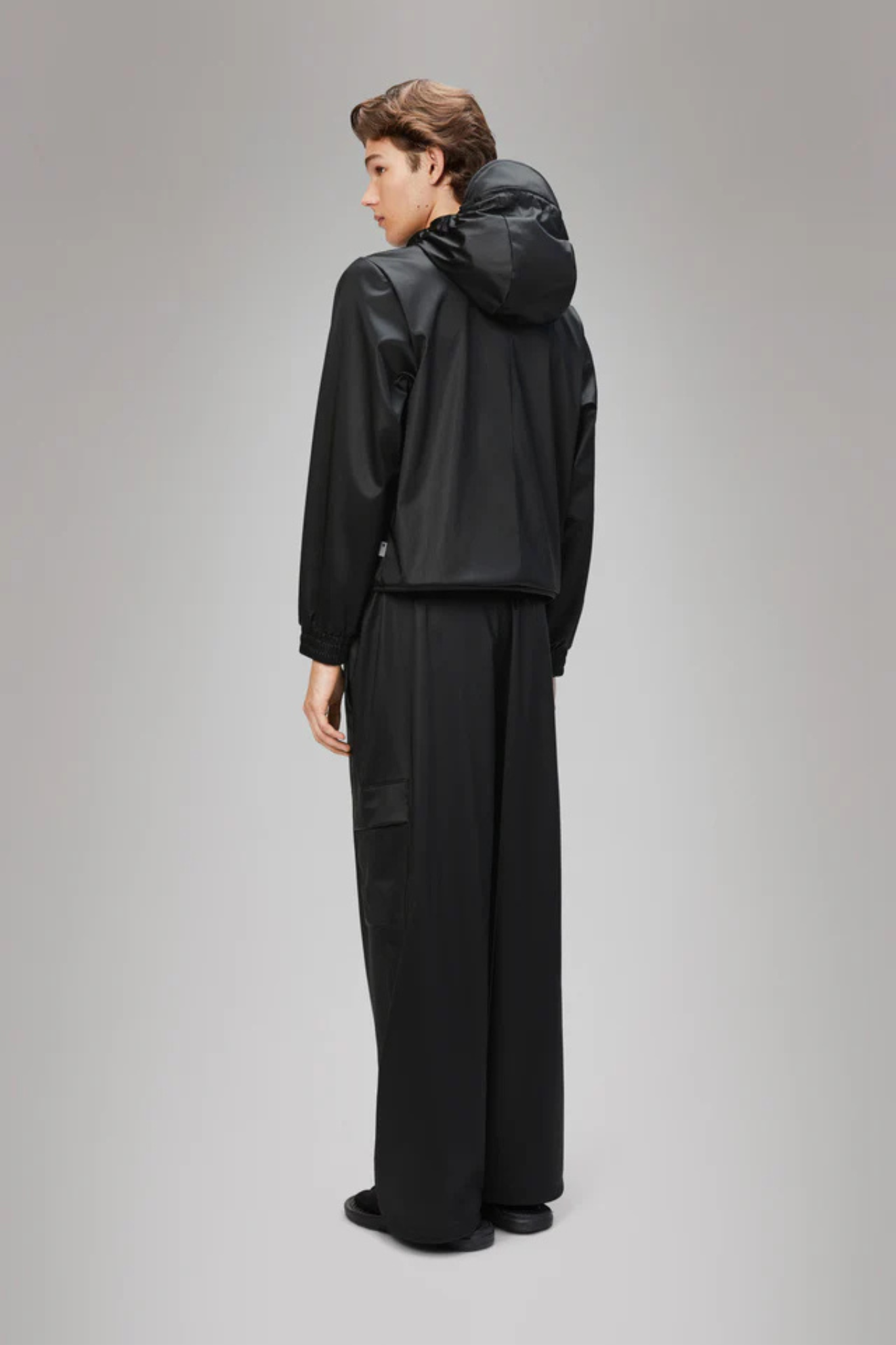 Model wearing the Rains string jacket W3 in black. Back view