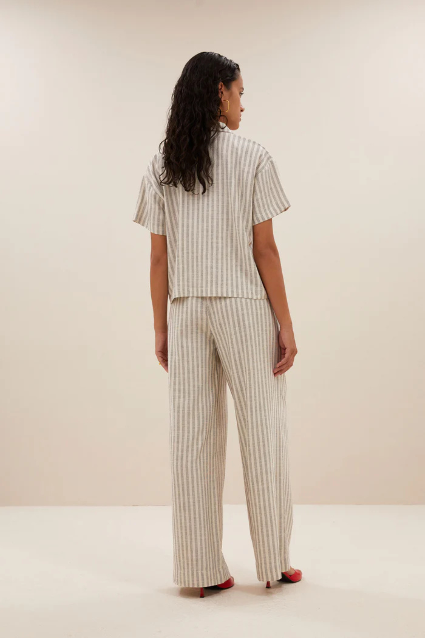 Model wearing the By-Bar Benji striped marine pants in beige and white. Back view