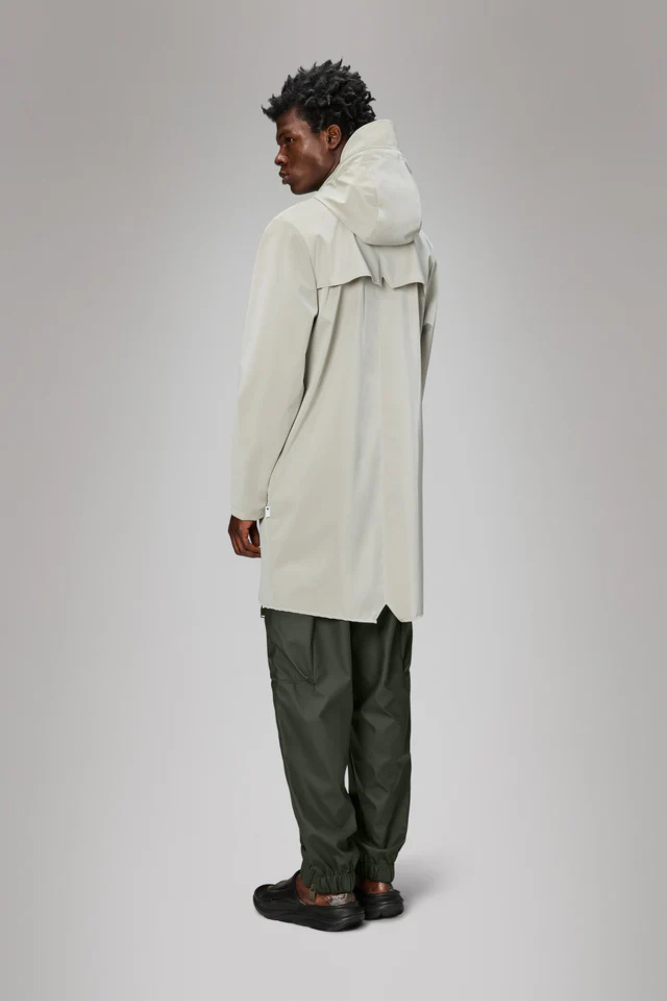 Model wearing the Rains long jacket W3 in white. Back view