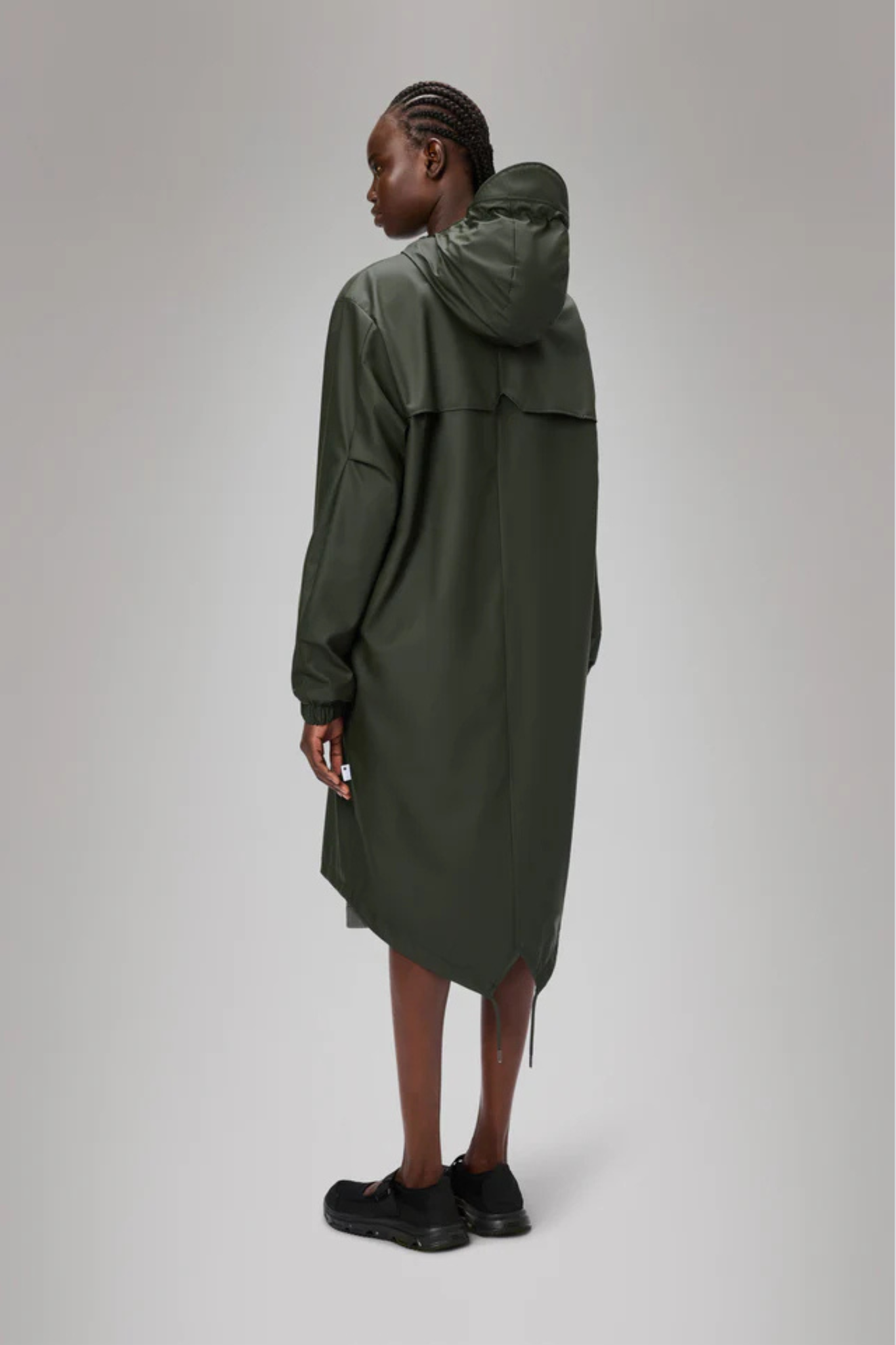 Model wearing the Rains fishtail parka W3 in green. Back view