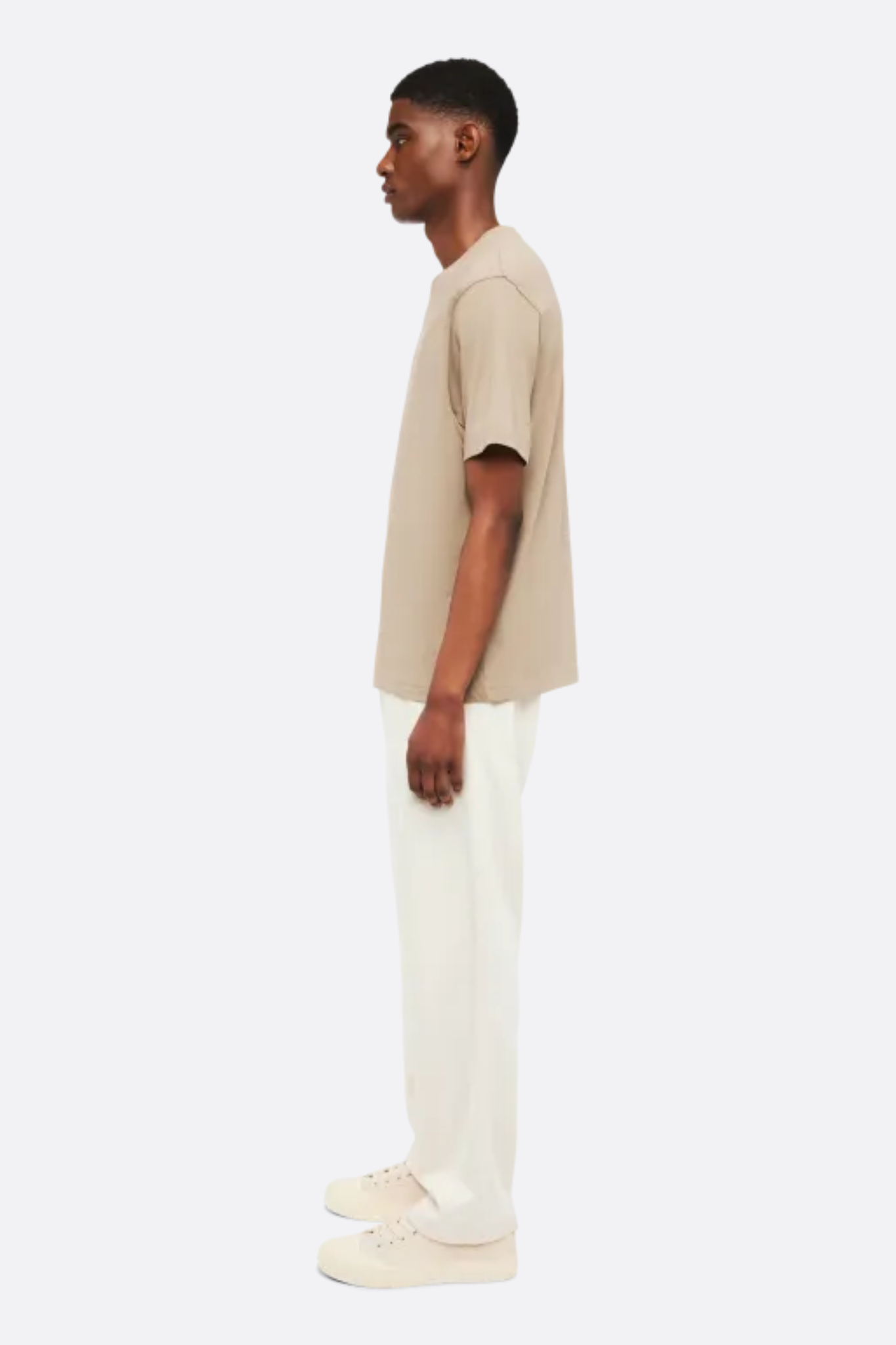 Model wearing the Drykorn raphael t-shirt in beige. Side view
