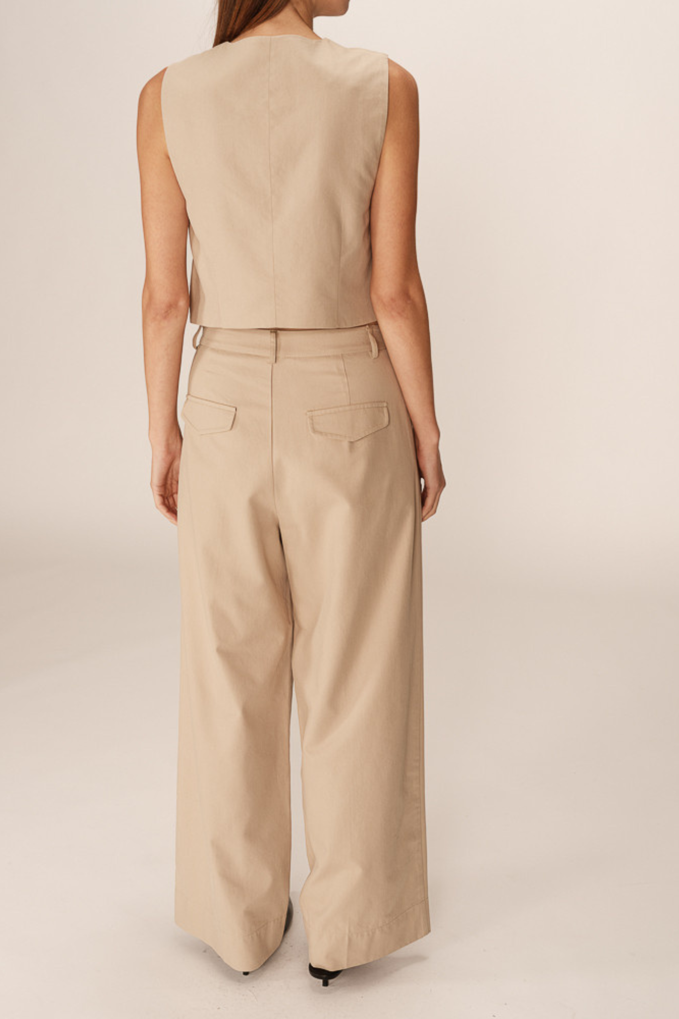 Model wearing the Grace & Mila peter pants in beige. Back view