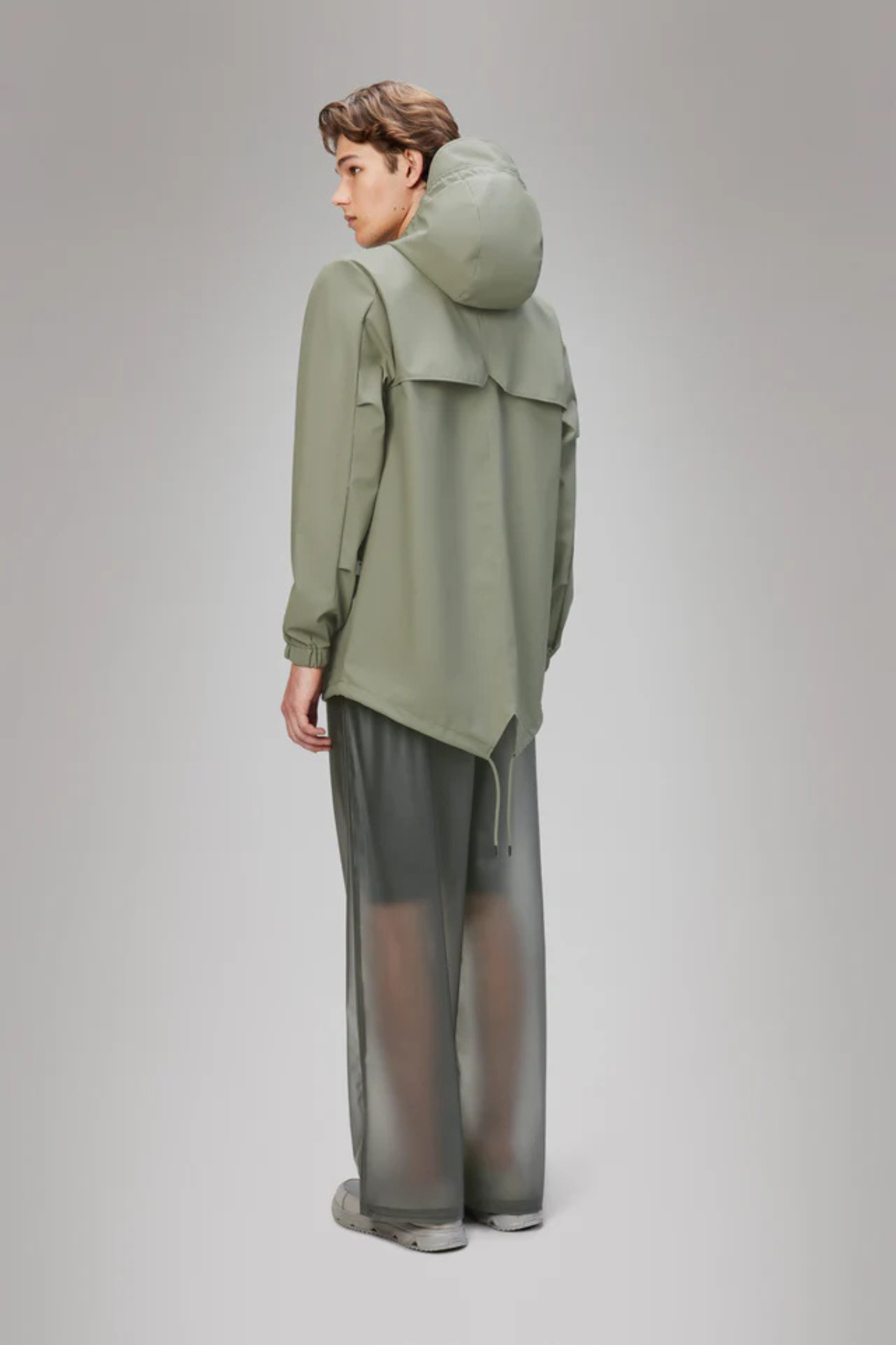 Model wearing the Rains fishtail jacket W3 in green. Back view