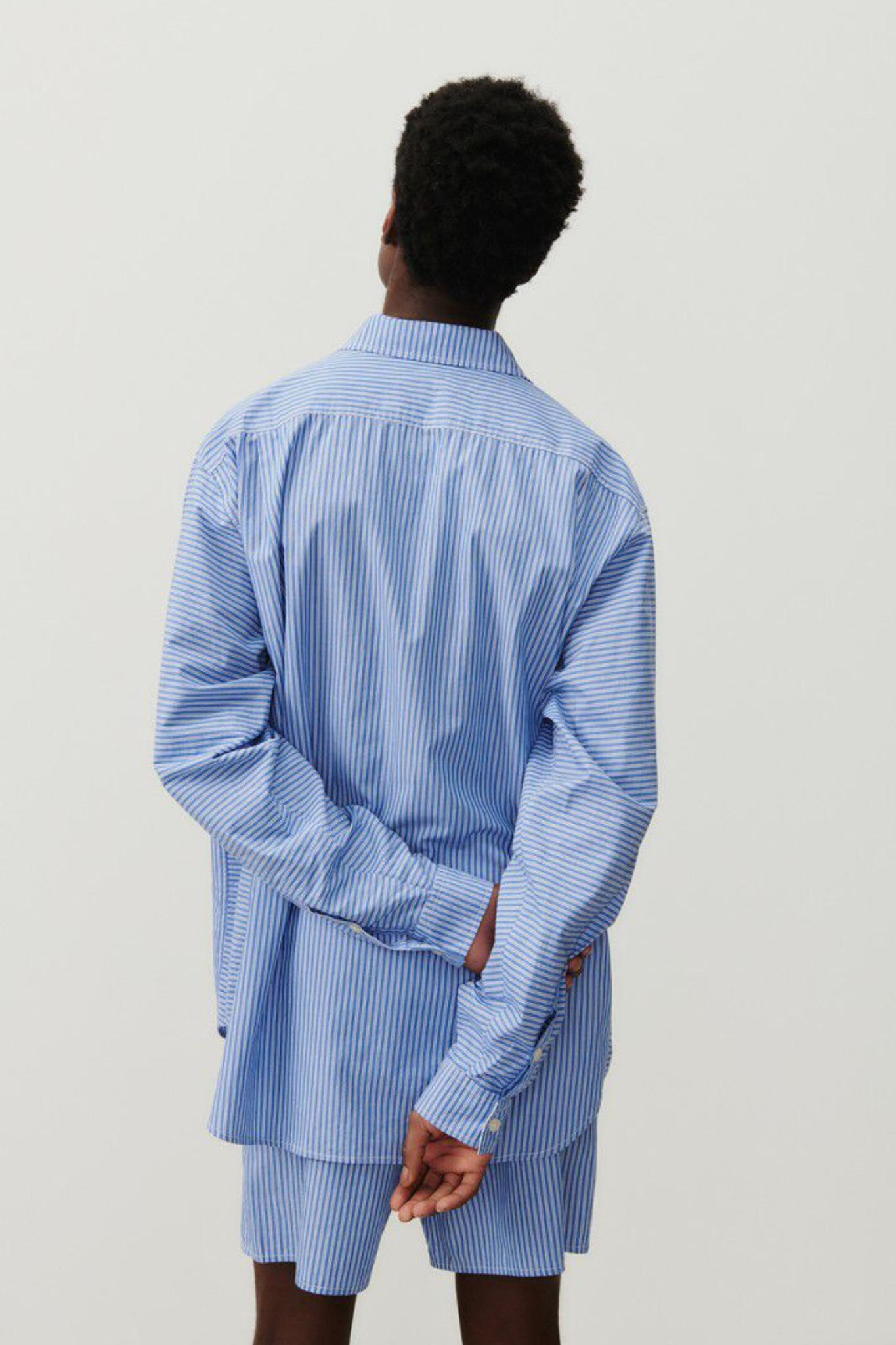 Model wearing the American Vintage zatybay shirt in aqua stripes. Back view