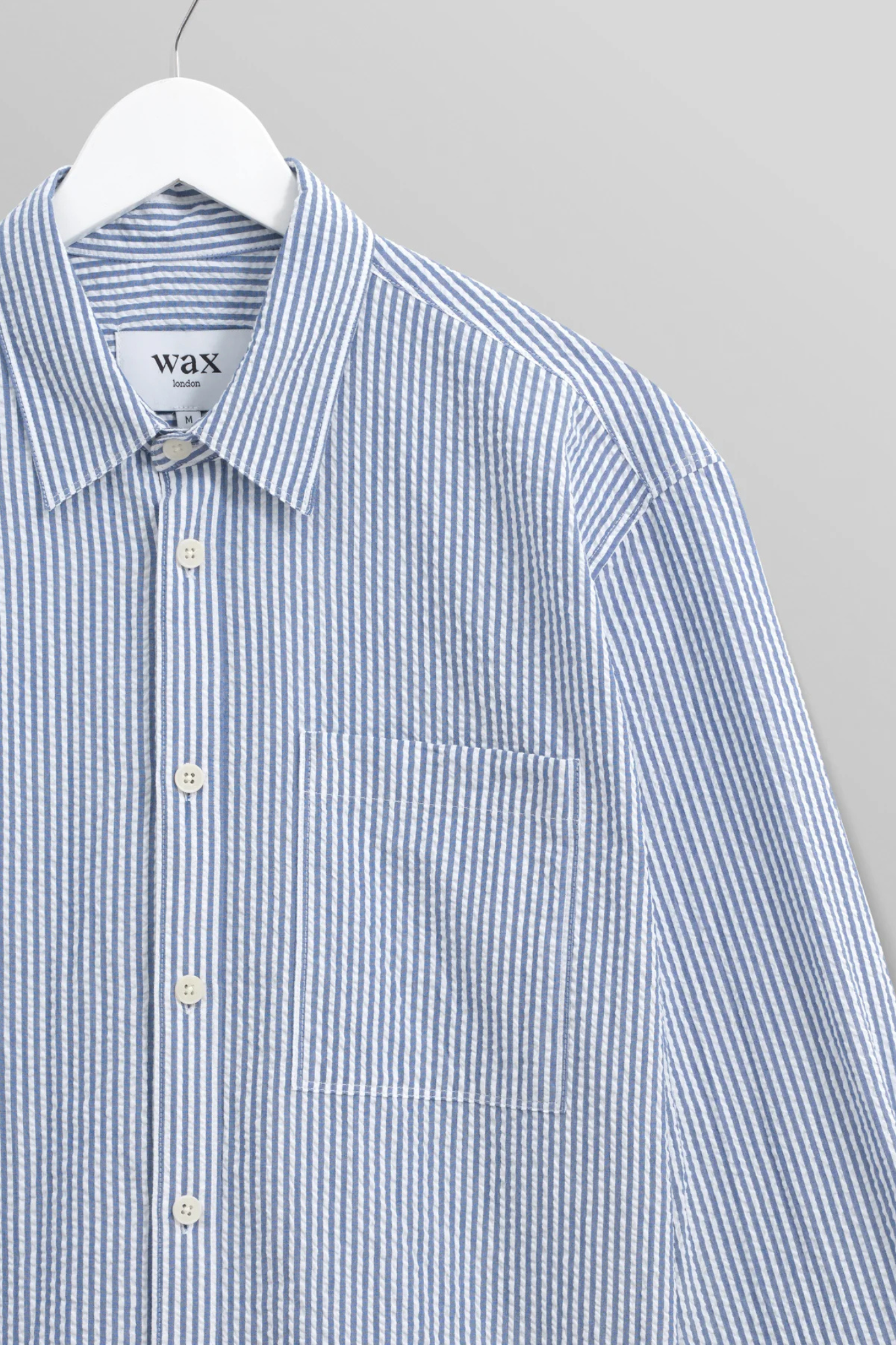Wax London rove seersucker stripe shirt in blue. Front flatlay view