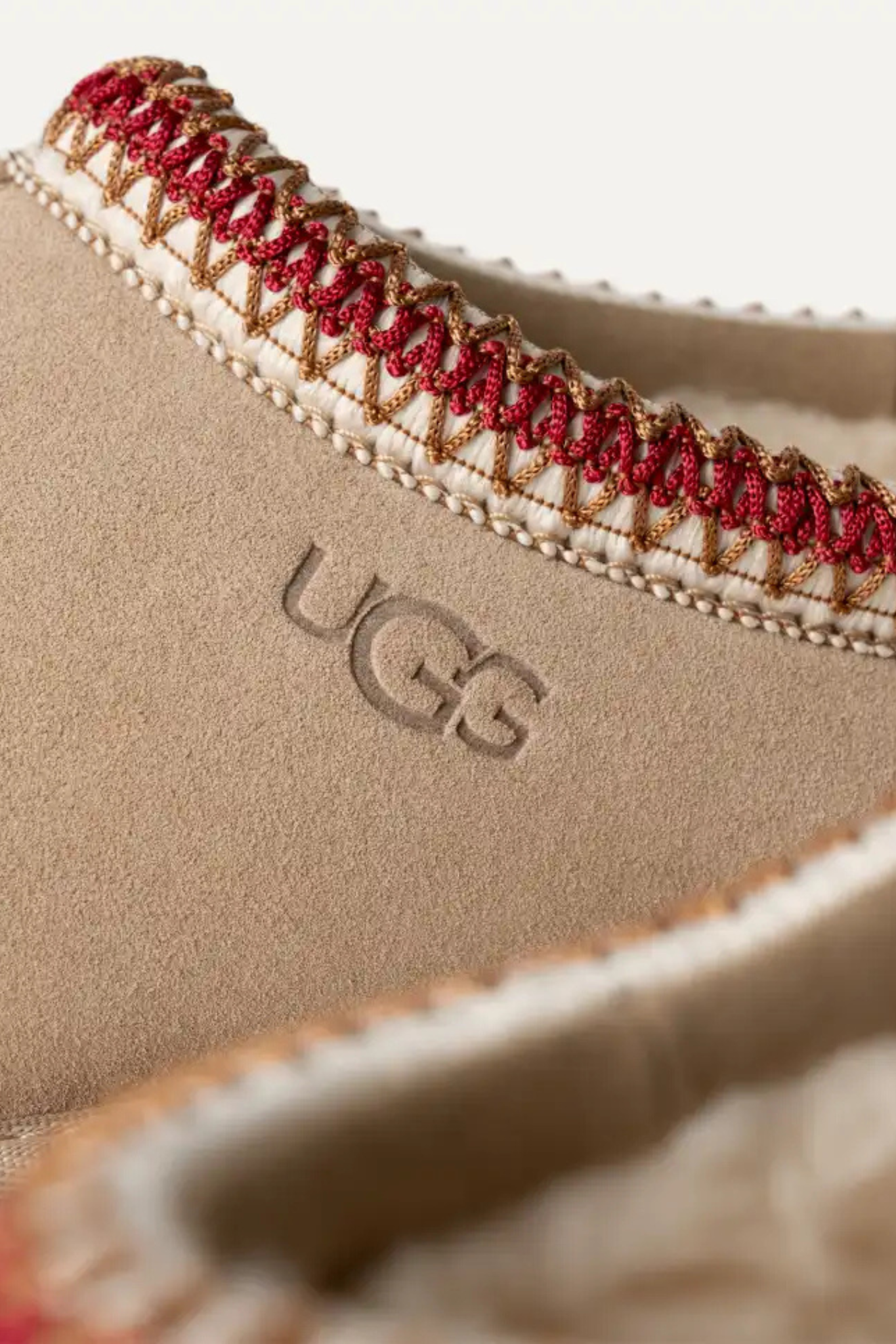 UGG women tasman in sand/dark cherry. Close logo view