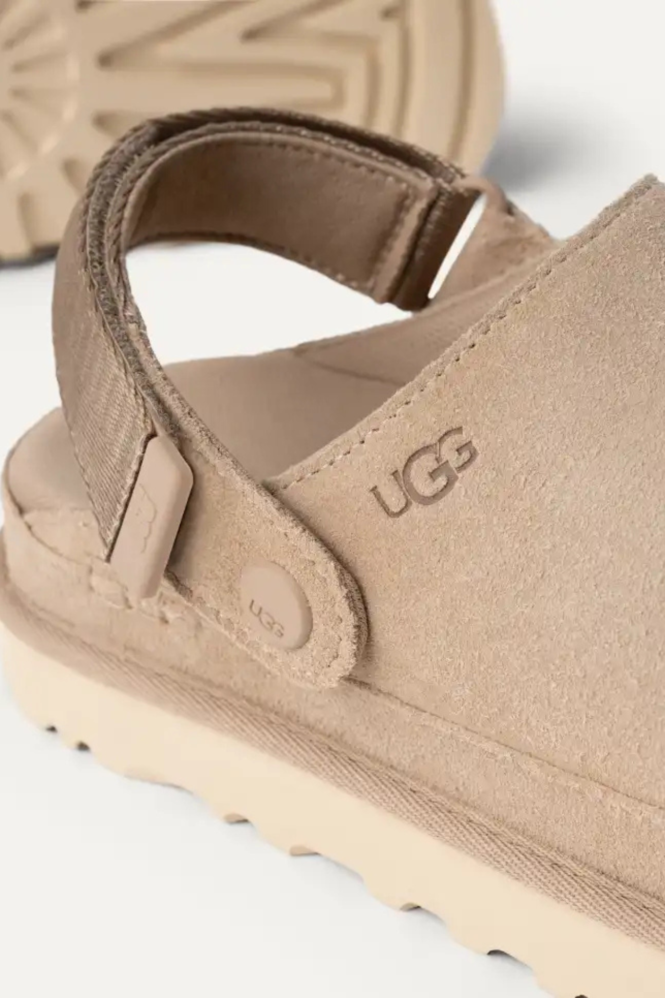 UGG women goldenstar clog in sand. Close logo view