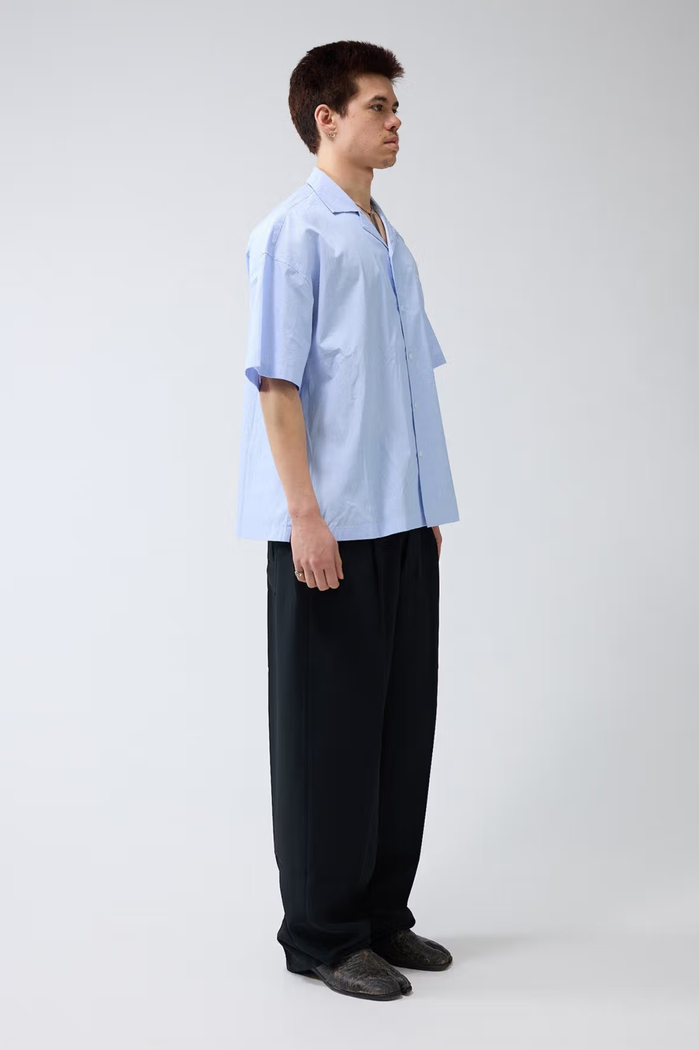 Model wearing the New Amsterdam wijk shirt in white/blue stripes. Side view