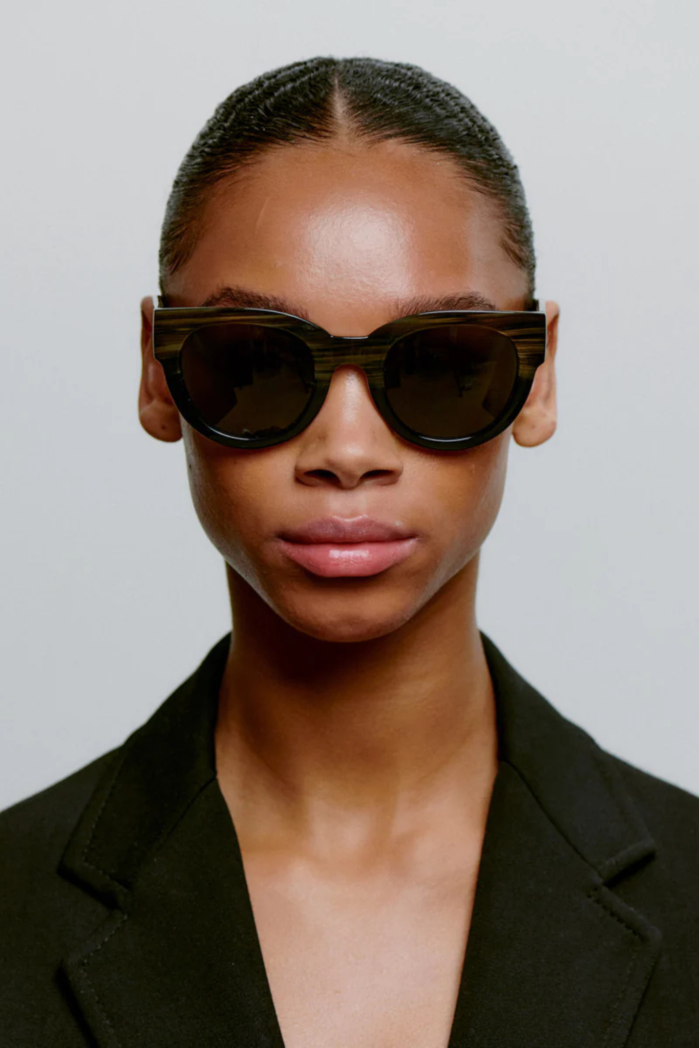 Model wearing the A. Kjaerbede lilly sunglasses in striped horn/black. Front view