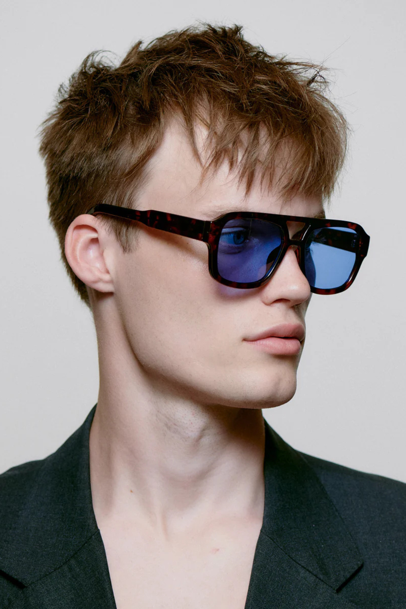 Model wearing the A. Kjaerbede kaya sunglasses in demi tortoise (blue lens). Side view