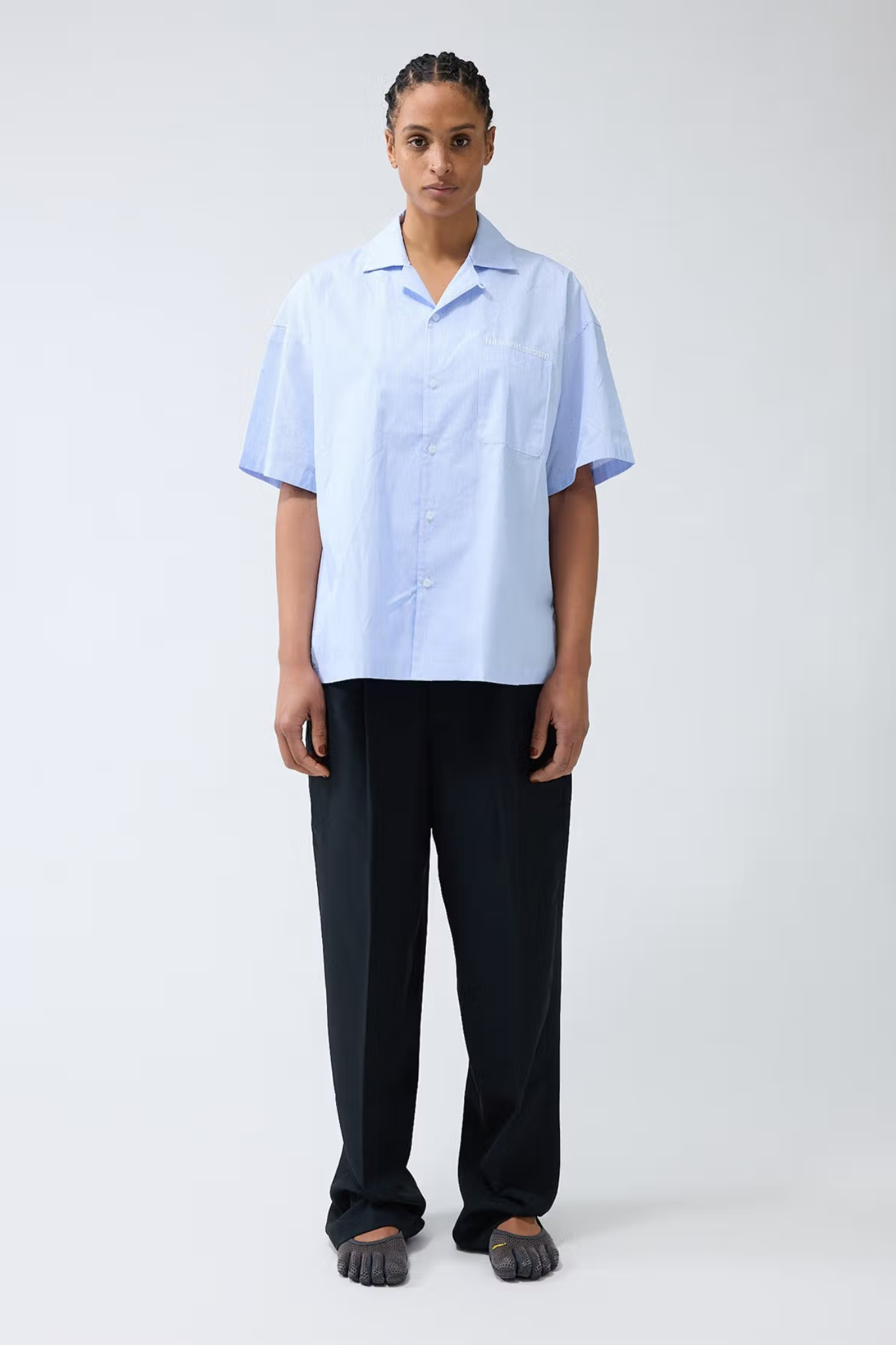 Model wearing the New Amsterdam wijk shirt in white/blue stripes. Front view