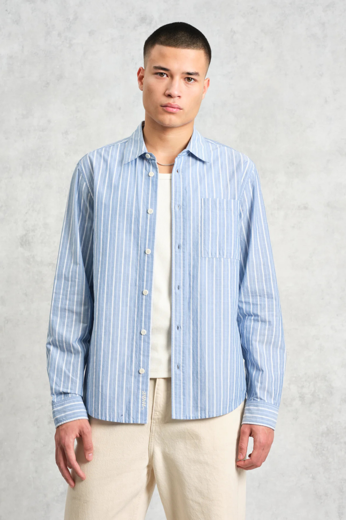 Model wearing the Wax London rove poplin stripe shirt in blue. Front view