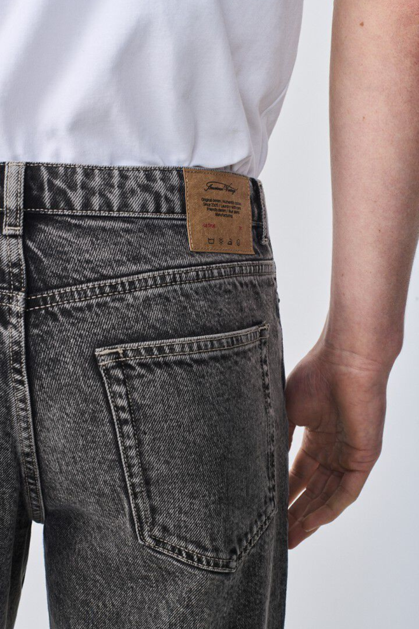 Model wearing the American Vintage yobday-b jeans in grey salt and pepper. Close back view