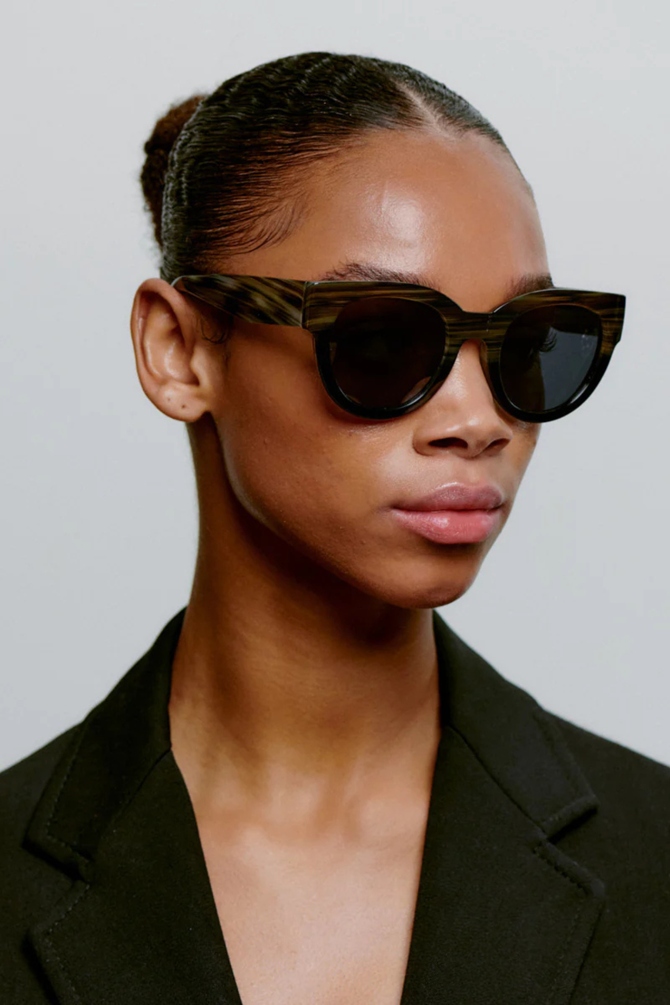 Model wearing the A. Kjaerbede lilly sunglasses in striped horn/black. Side view