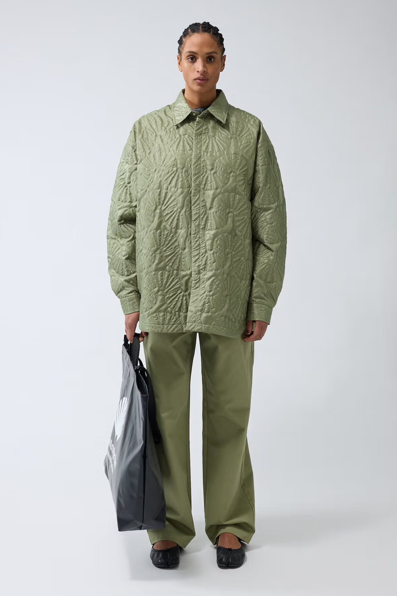 Model wearing the New Amsterdam shell quilted overshirt in green. Front view