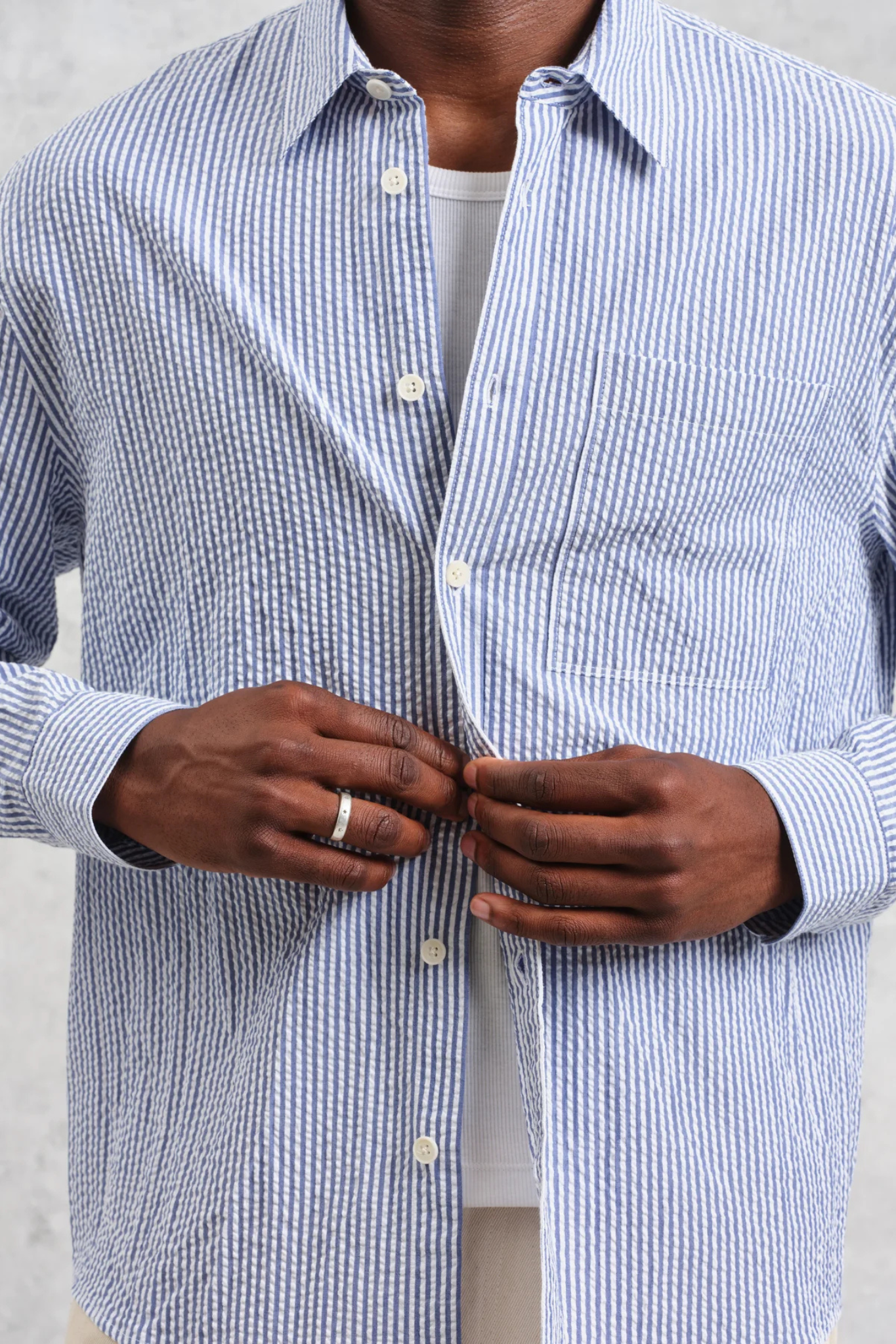 Model wearing the Wax London rove seersucker stripe shirt in blue. Front view