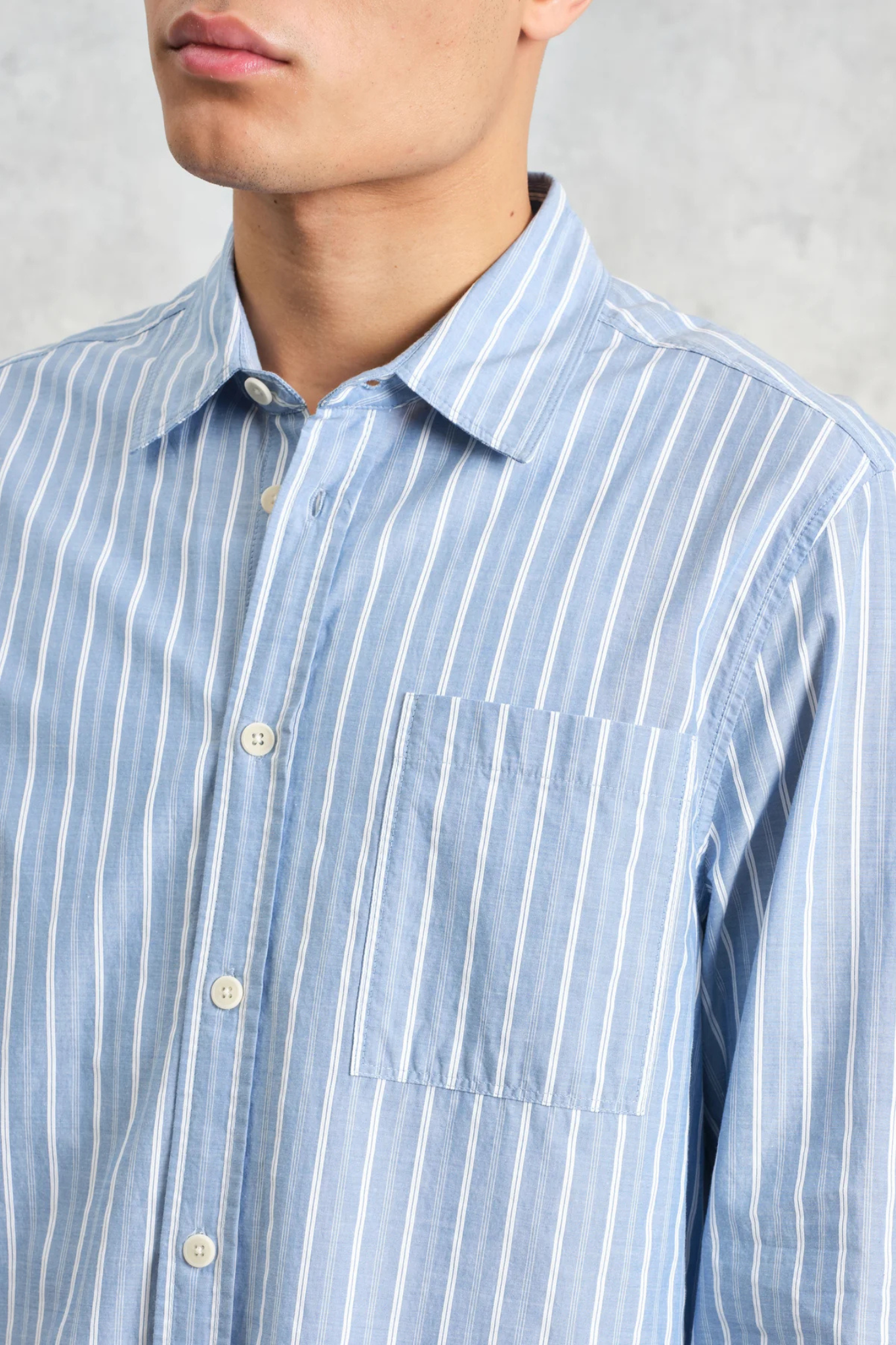 Model wearing the Wax London rove poplin stripe shirt in blue. Close front view